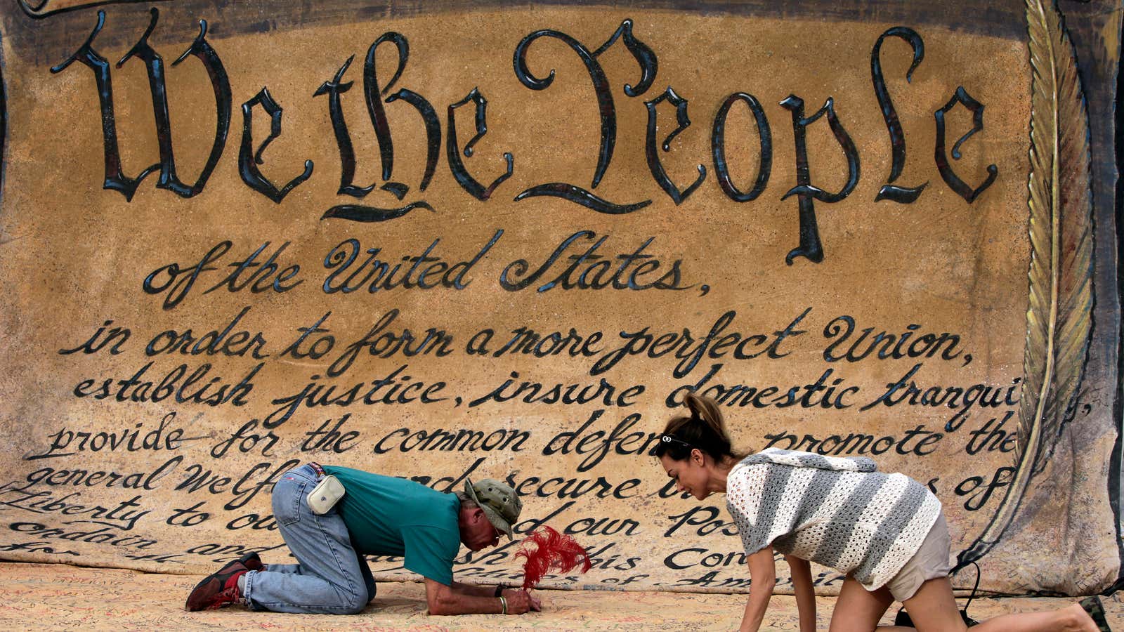 People sign a huge copy of U.S. Constitution at an “Occupation of Washington” march camp in Washington, October 10, 2011.