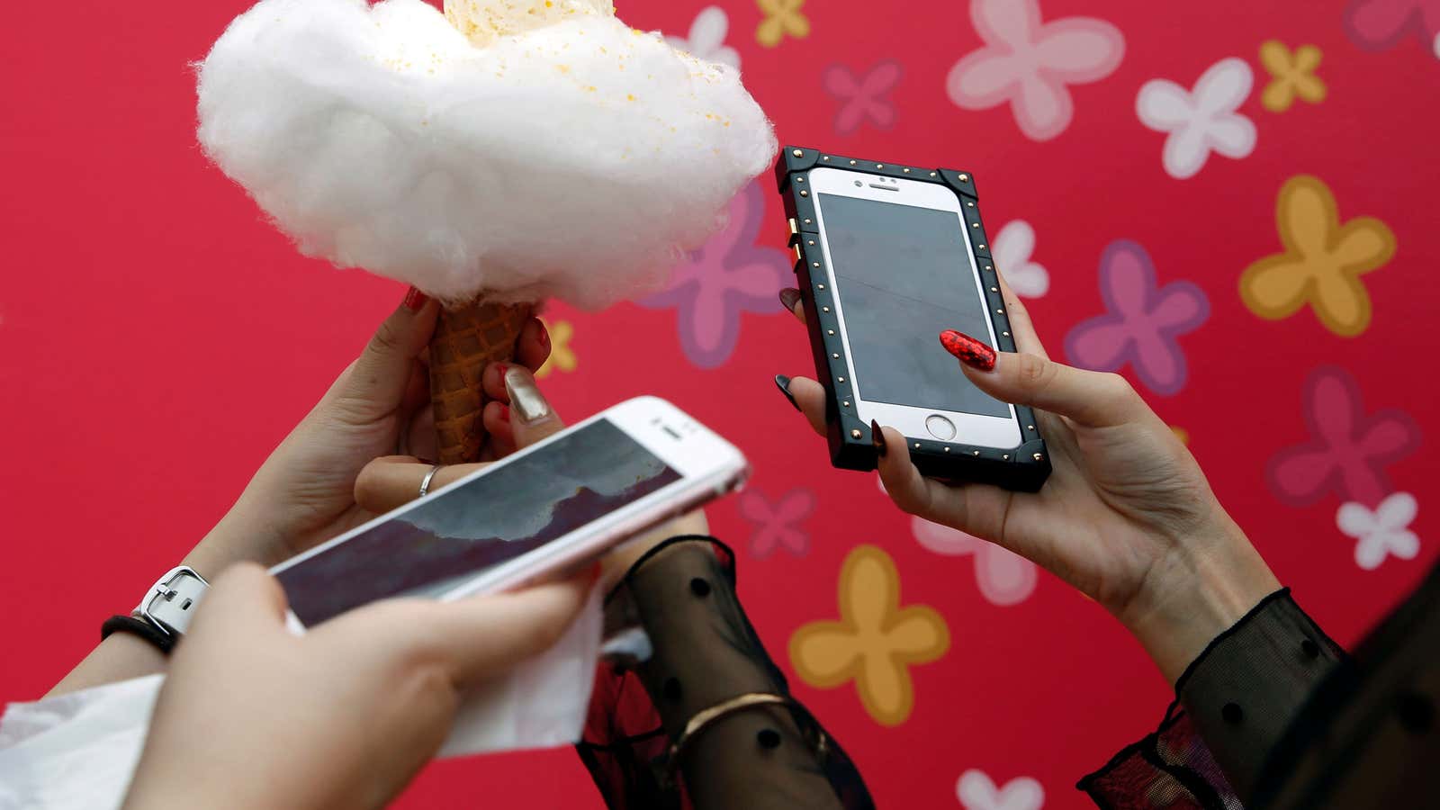 Instagramer SHIHO and her friend look at their mobile after taking photos of Anywhere Door’s ‘Cotton Candy Ice’ during the Photogenic Sweets Festa at a…