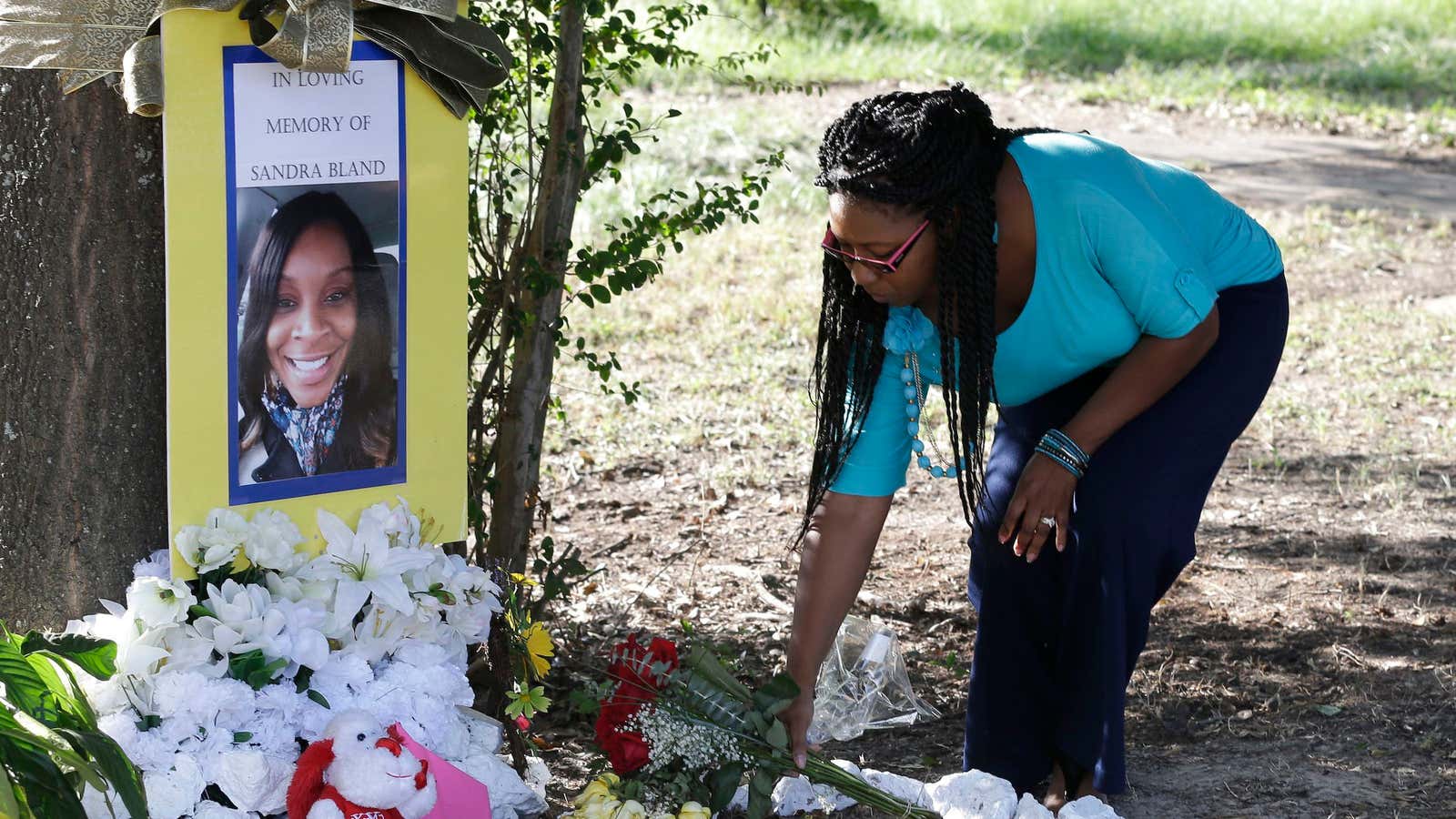 A woman puts out flowers in memory of Sandra Bland.