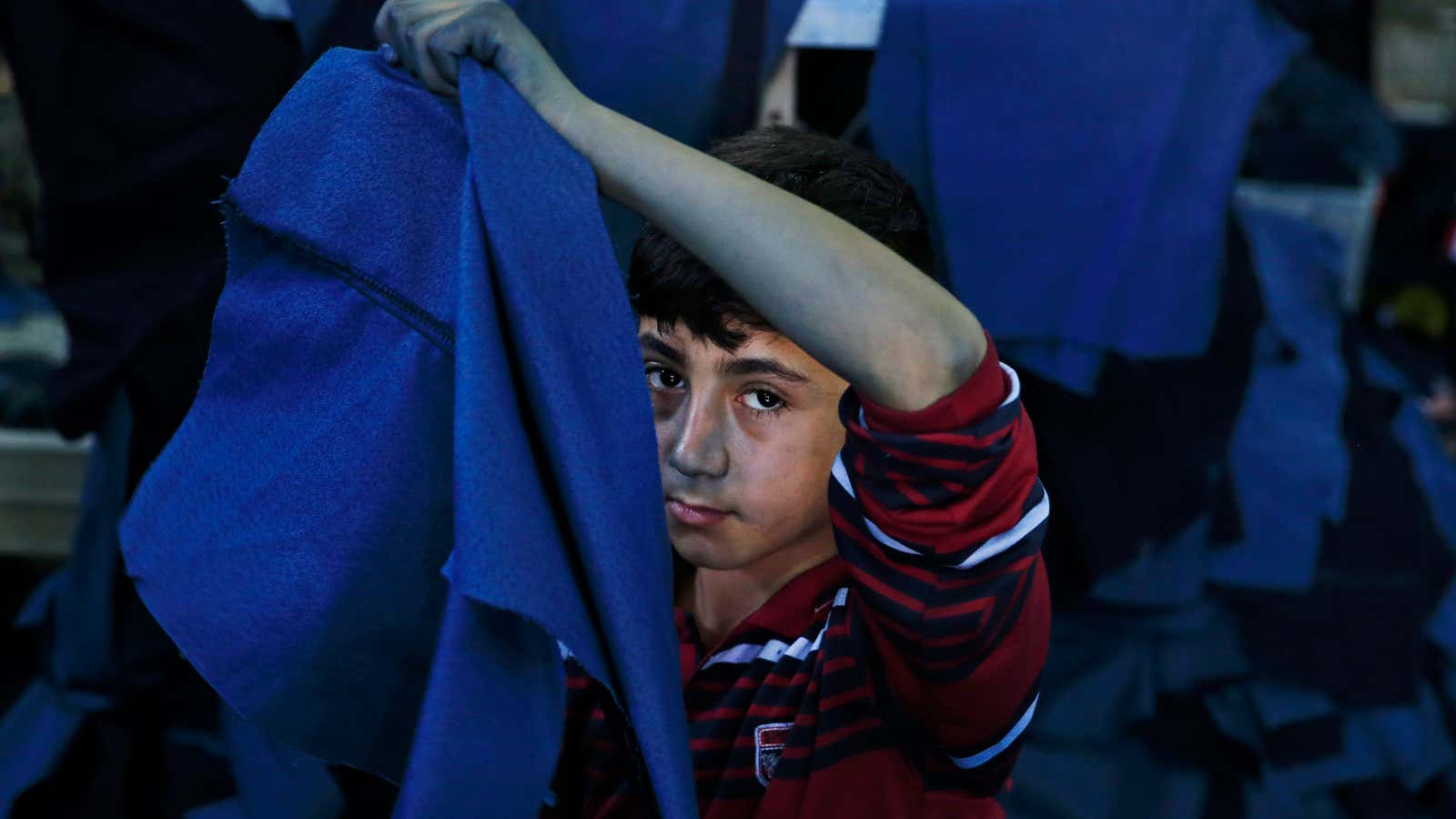A Syrian refugee child works at a clothing workshop in Turkey.