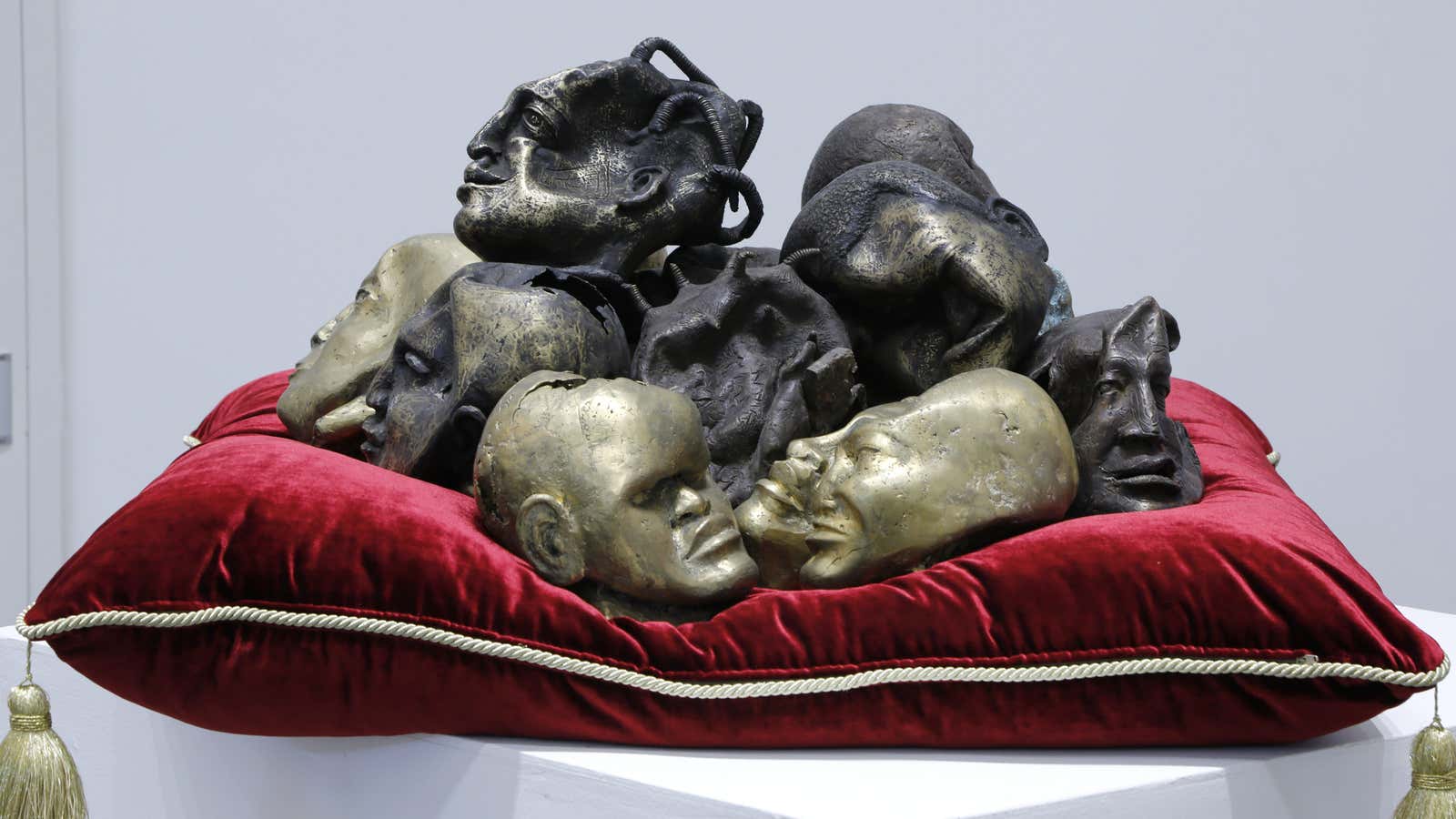 Siriki Ky’s, Têtes précieuses (Precious heads), sculpted bronze heads piled on a regal red pillow, laments how the continent has forgotten the wisdom from its griots