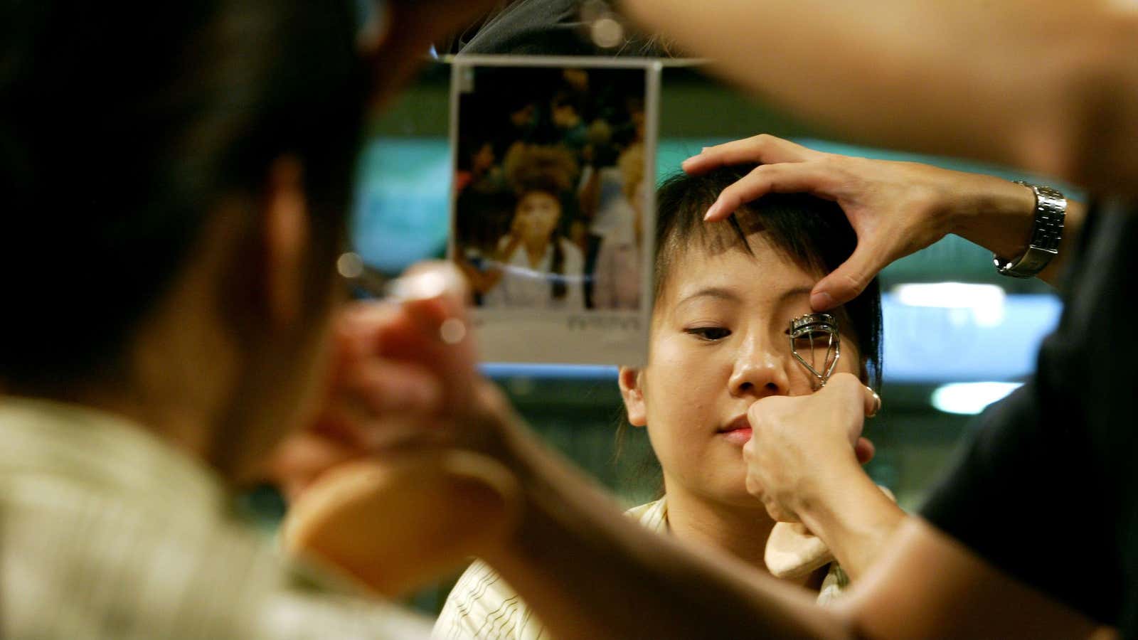 A make up artist works with a customer in Shanghai.