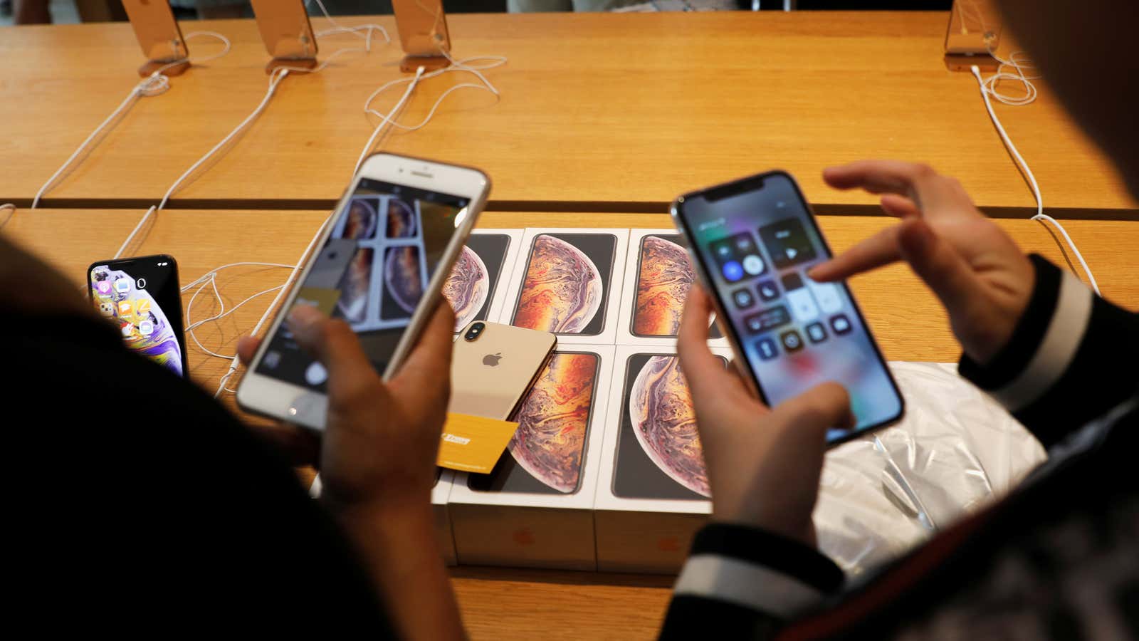 Customers look at some iPhones in an Apple store.