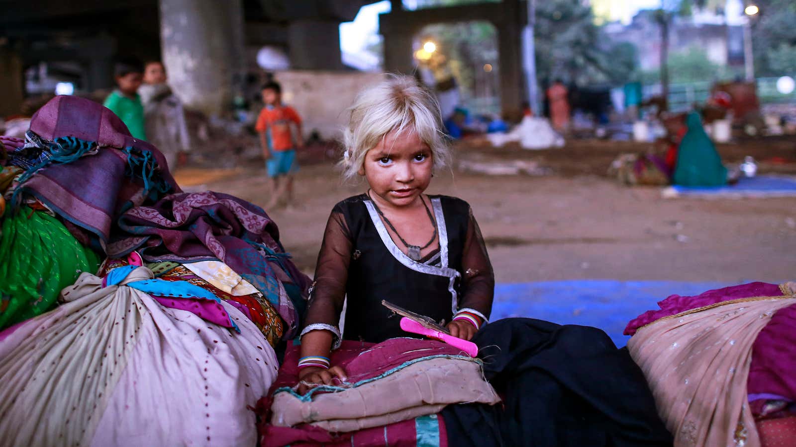 Five-year-old Nasreen rests with her family’s belongings in Mumbai, India.