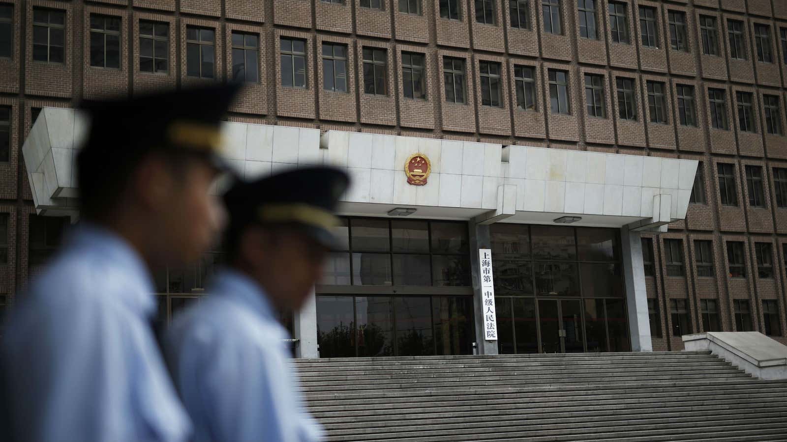 Police patrol outside the Shanghai No.1 Intermediate People’s Court, where a couple working as investigators in China are being tried.