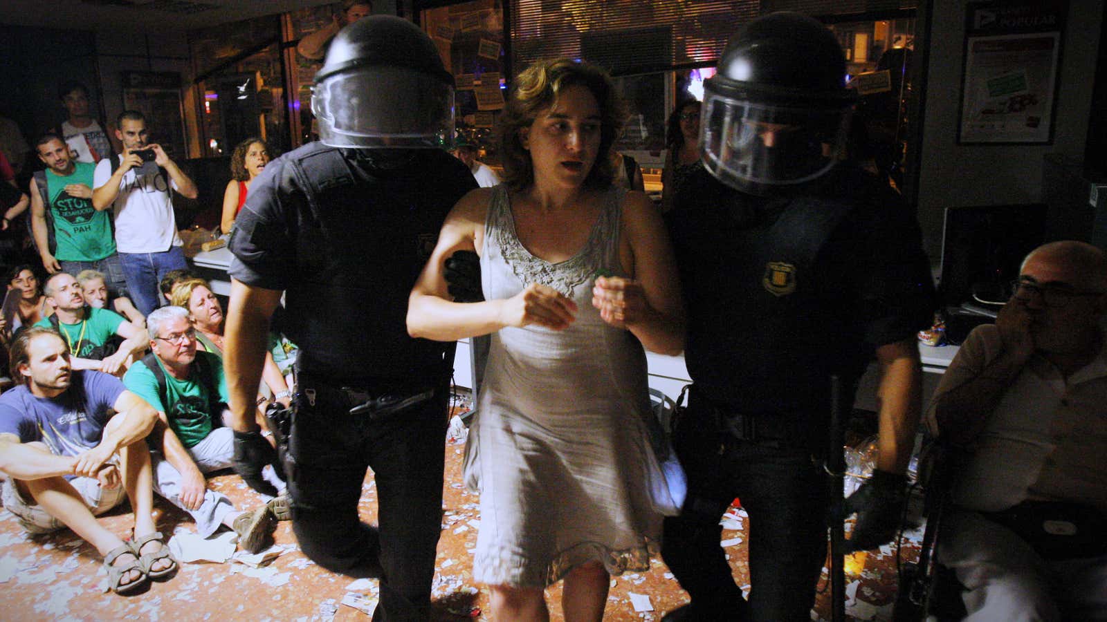 Ada Colau, new mayor of Barcelona, is carried out by riot police officers after occupying a bank in 2013