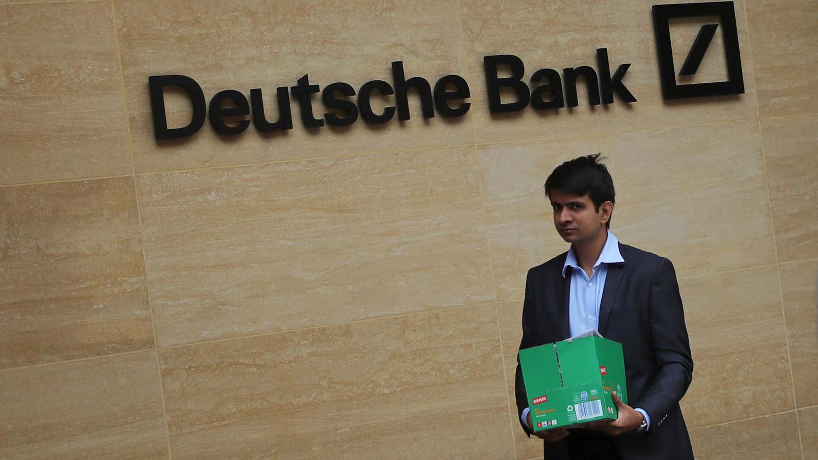 A man carrying a box leaves a Deutsche Bank office in London, Britain July 8, 2019.