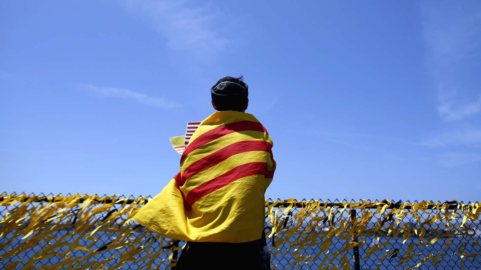 Draped in a South Vietnamese flag, a former refugee aboard the USS Midway in April 2015.