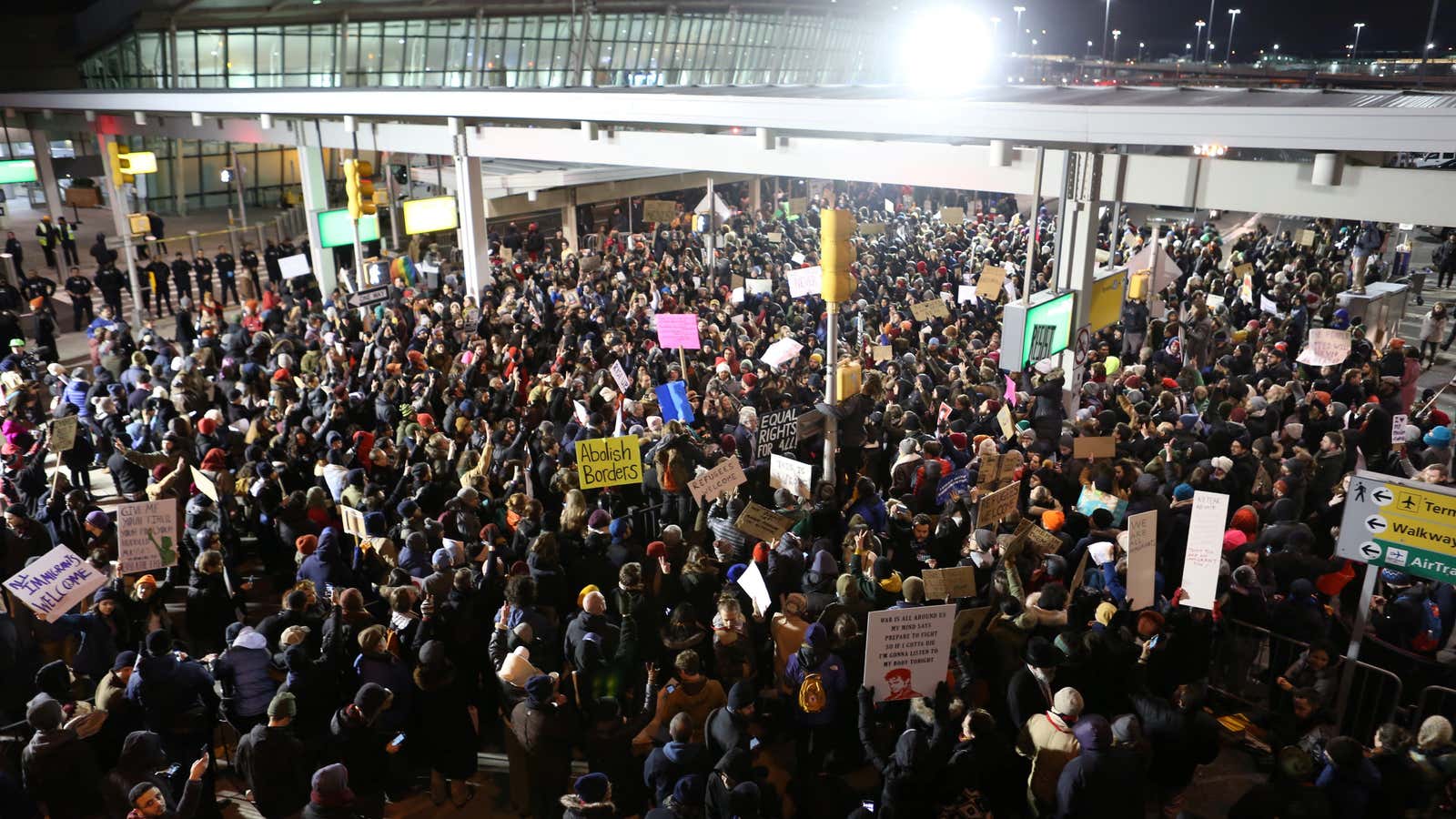 Protestors gather outside Terminal 4 at JFK airport on Saturday.