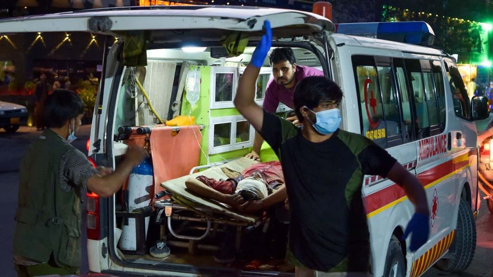 Medical staff transport the injured after two explosions outside the Kabul airport.