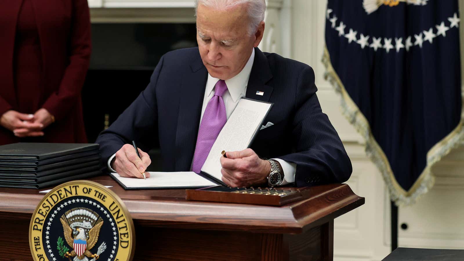 U.S. President Joe Biden signs an executive order as part of his administration’s plans to fight the coronavirus disease (COVID-19) pandemic during a COVID-19 response…