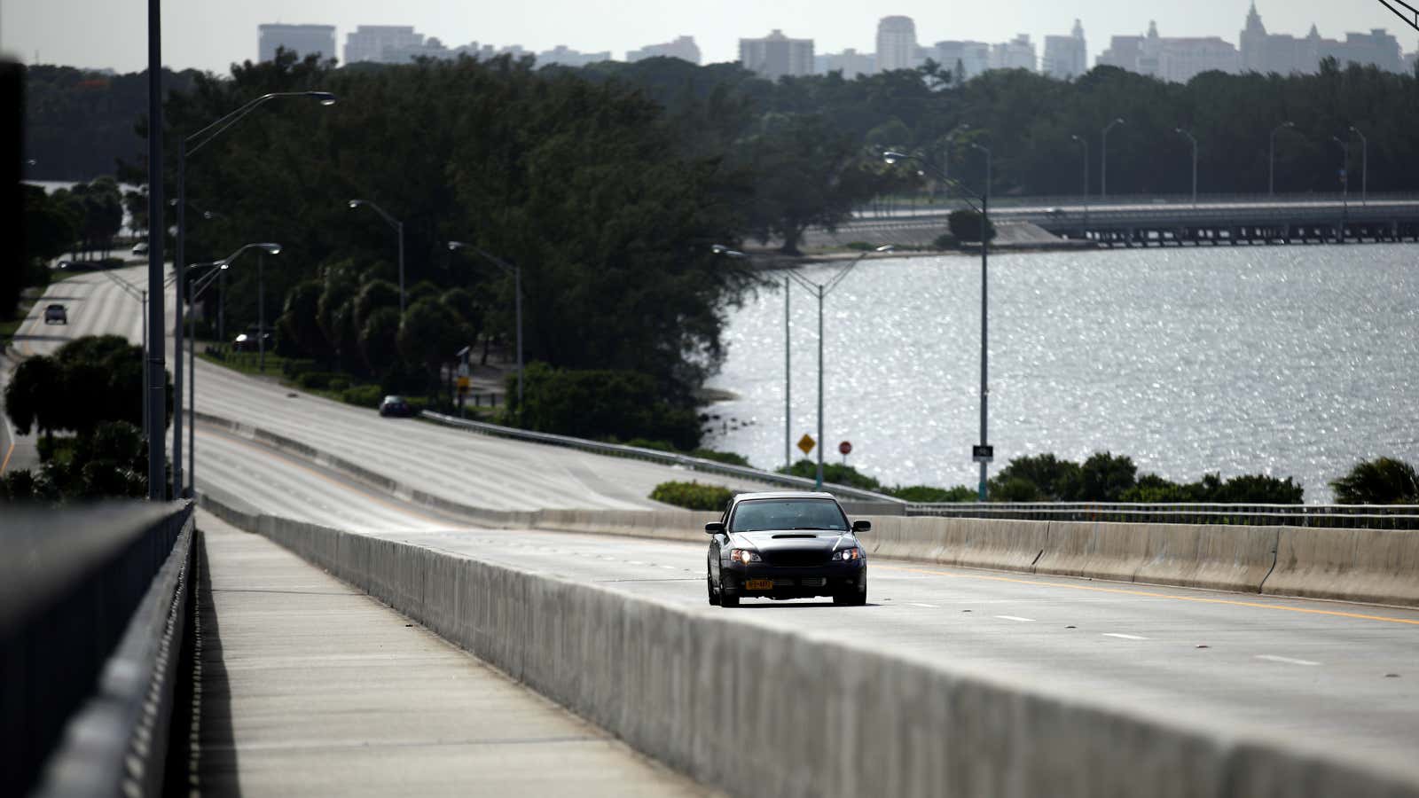 A car drives on an empty highway in downtown Miami.