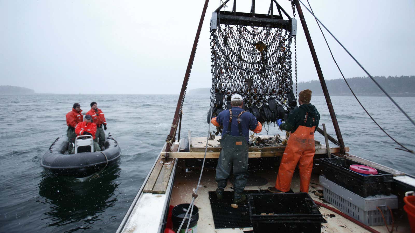 In this photo made Saturday, Dec. 17, 2011, Marine Patrol officers, left, arrive for a routine inspection aboard scallop fisherman Donald Ricker’s boat off Harpswell,…