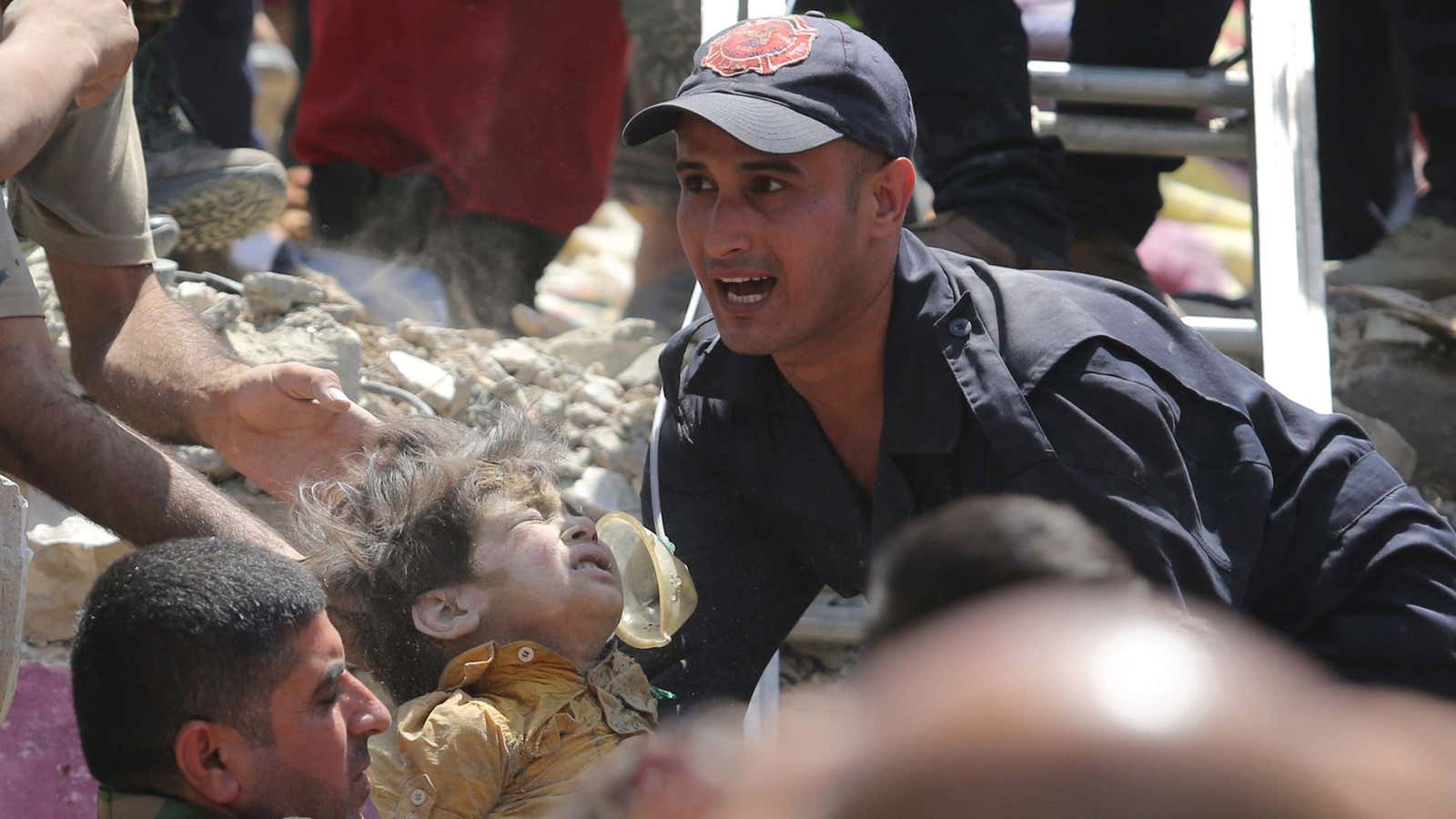 A man carries a wounded child to safety following a bomb in a Baghdad neighborhood.