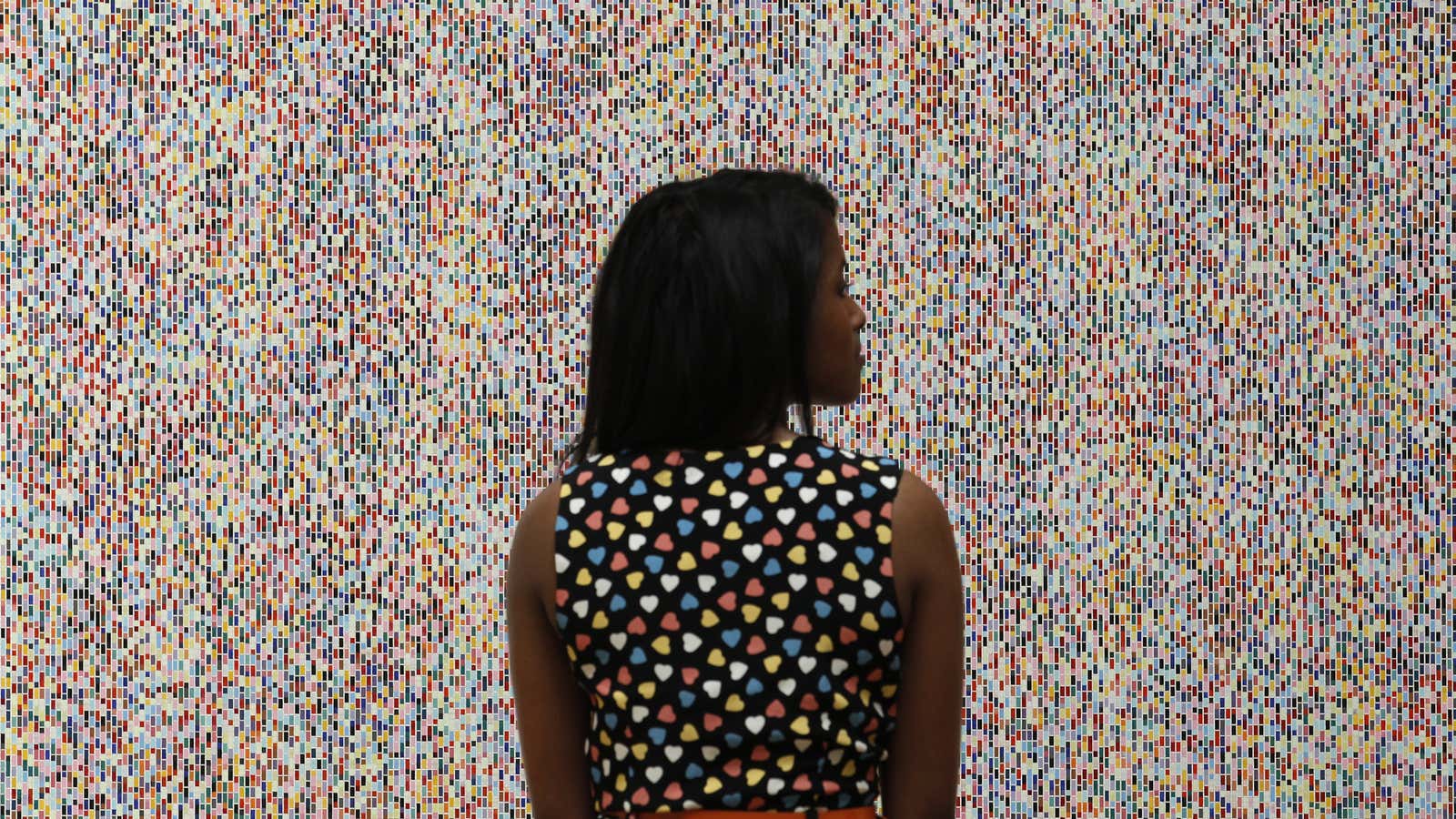 A visitor poses with artist James Hugonin’s “Binary Rhythm (I)” at the press view of the Summer Exhibition 2011 at the Royal Academy of Arts in London.