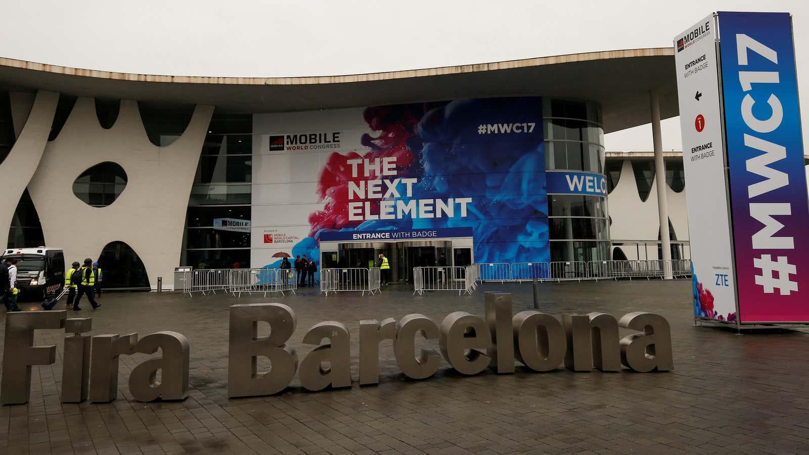 Workers walk past the main entrance of the Mobile World Congress in Barcelona, Spain February 24, 2017.