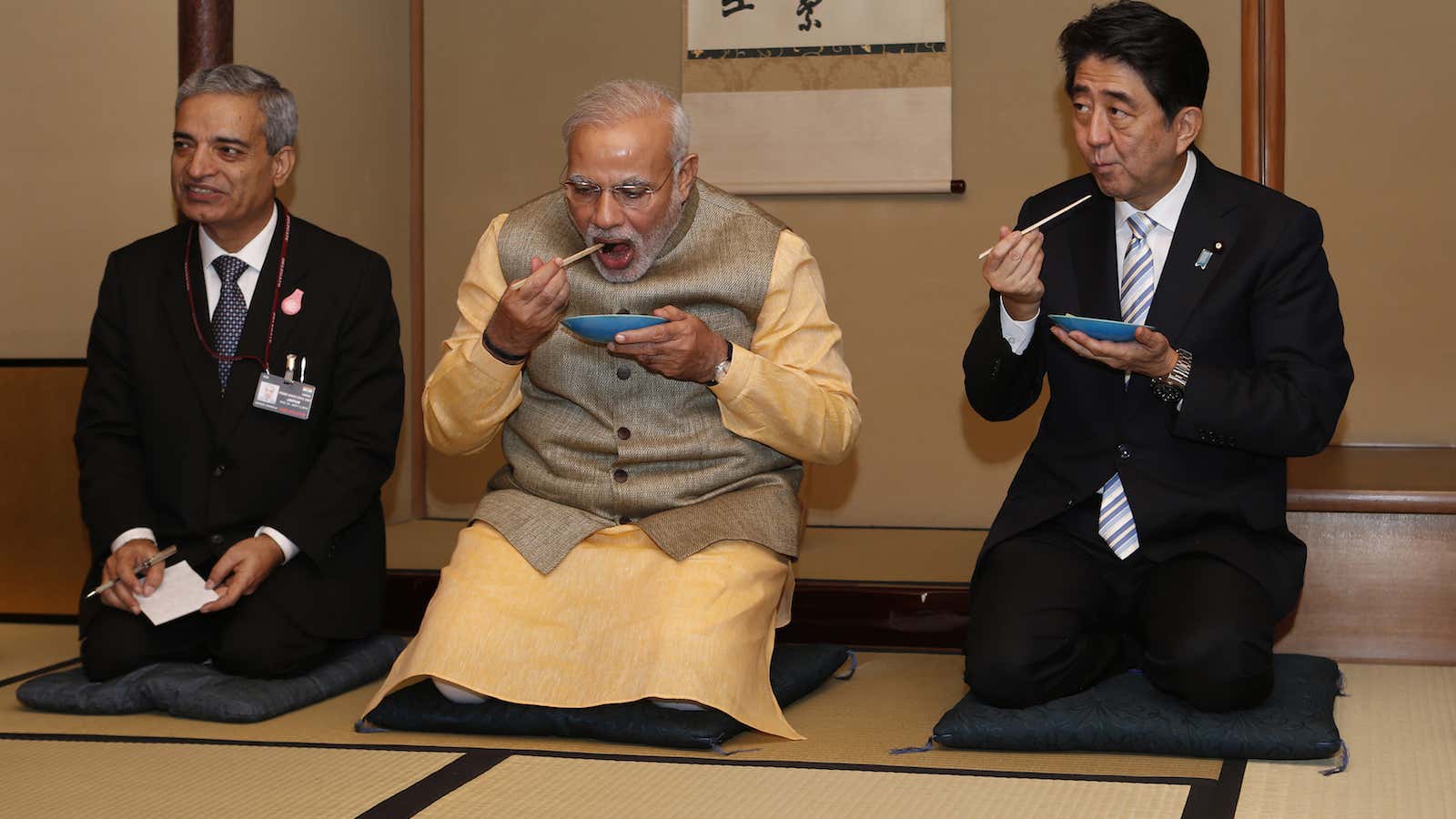 Narendra Modi (C) and Shinzo Abe (R) enjoy tea cakes.