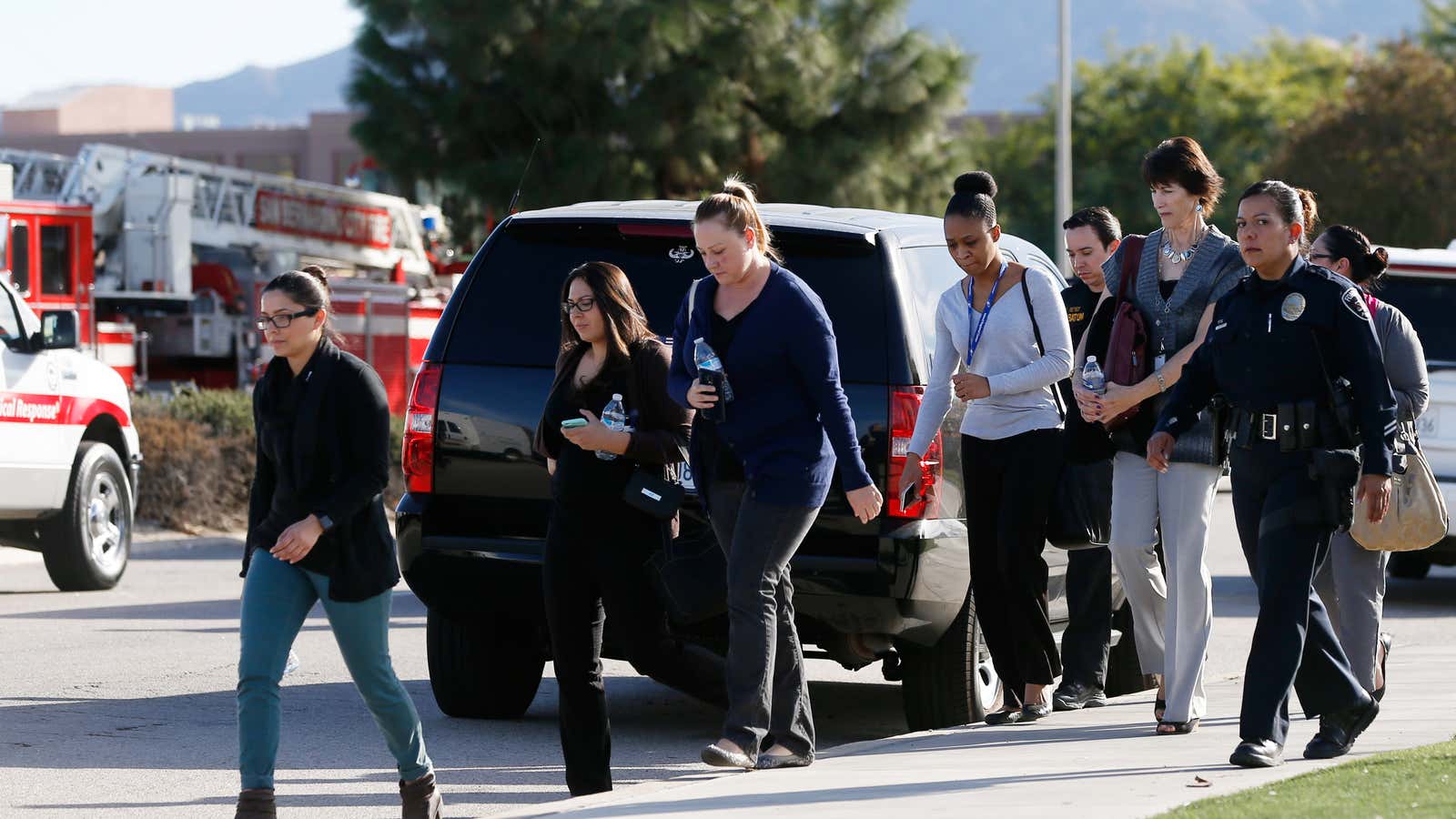 Police officers escort bystanders away as they secure the area after at least one person opened fire at a social services agency in San Bernardino, California, on Dec. 2.