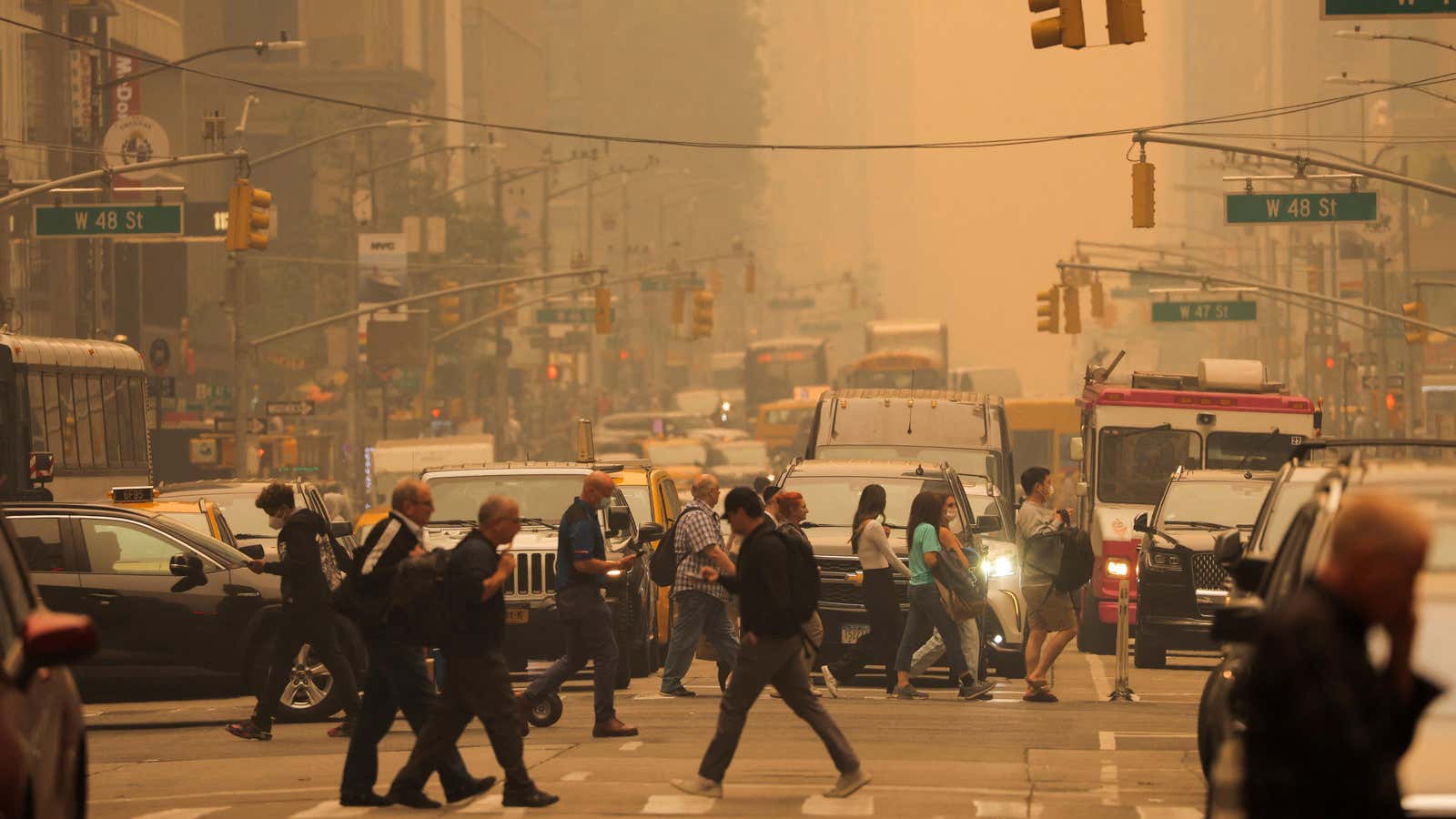 Menschen gehen auf der 6th Avenue, während Dunst und Rauch durch Waldbrände in Kanada New York City verursacht werden.