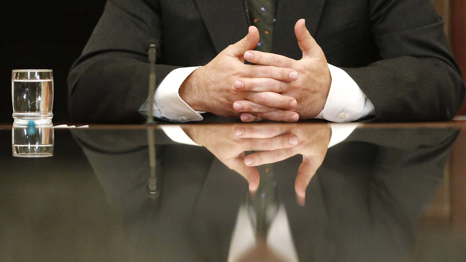 U.S. Federal Reserve Chairman Ben Bernanke is reflected in a glass table top as he holds town hall event for teachers at the Federal Reserve…