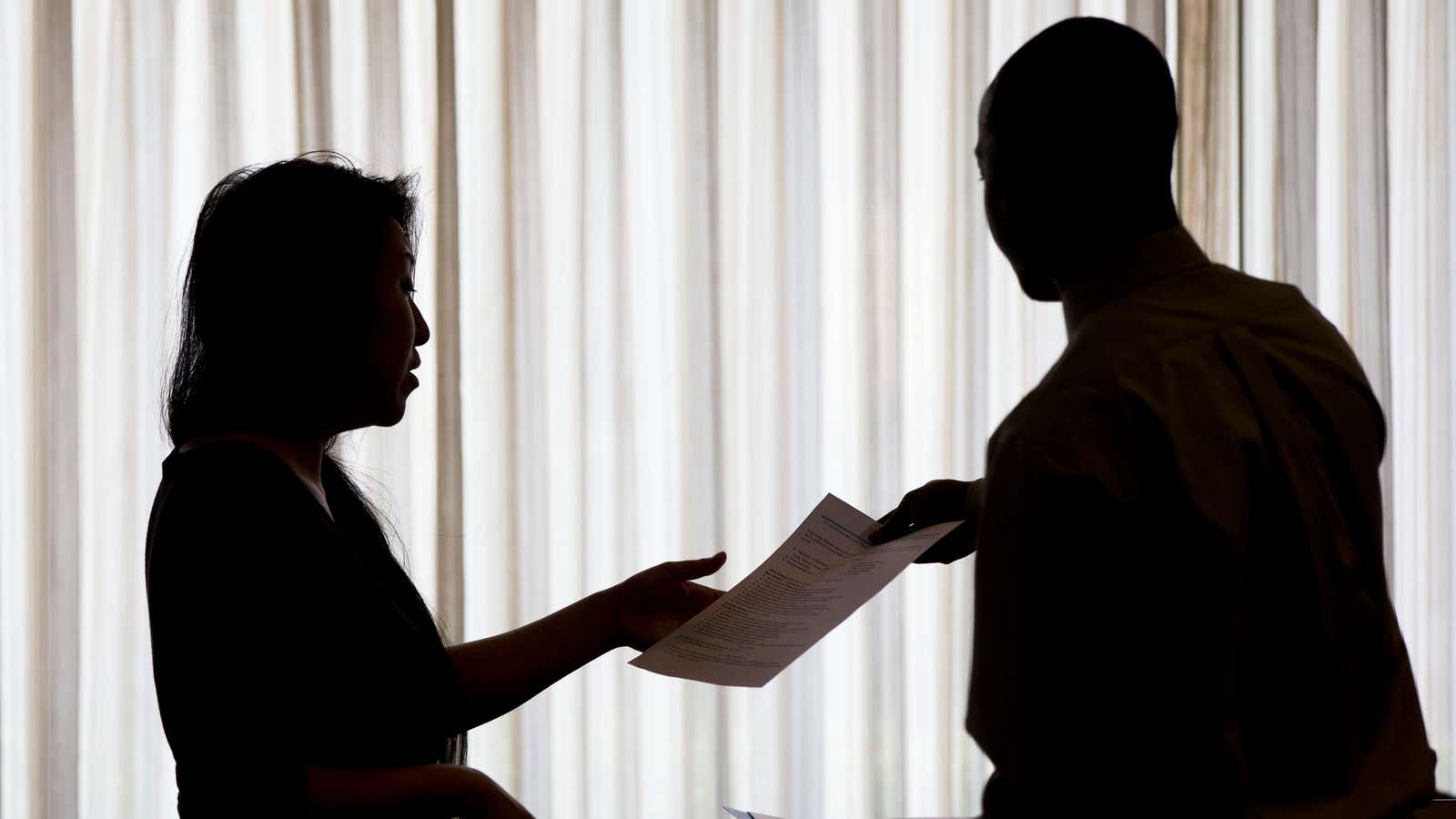 FILE – In this June 23, 2014, file photo, a recruiter, at left, takes the resume of an applicant during a job fair, in Philadelphia.…