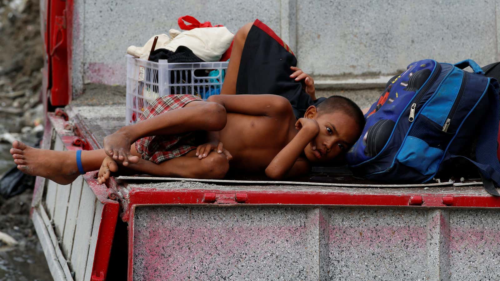 A resident lies on a truck with his belongings in Metro Manila, Philippines. (Reuters/Erik De Castro)