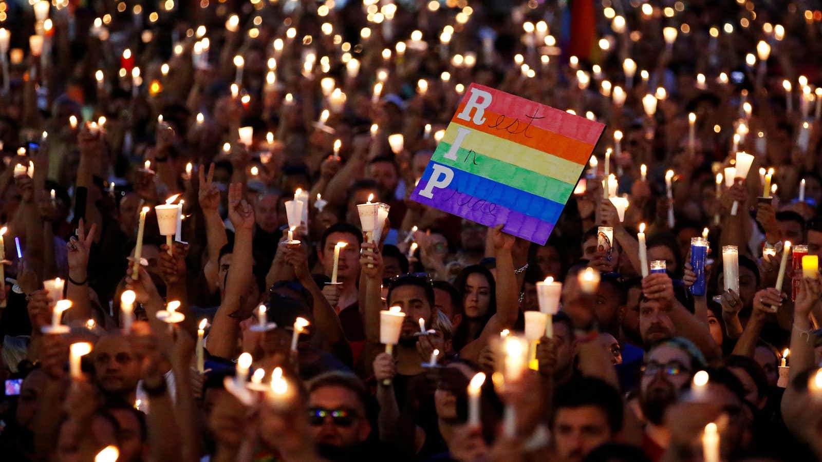 People take part in a candlelight memorial service the day after a mass shooting at the Pulse gay nightclub in Orlando, Florida, U.S. June 13,…