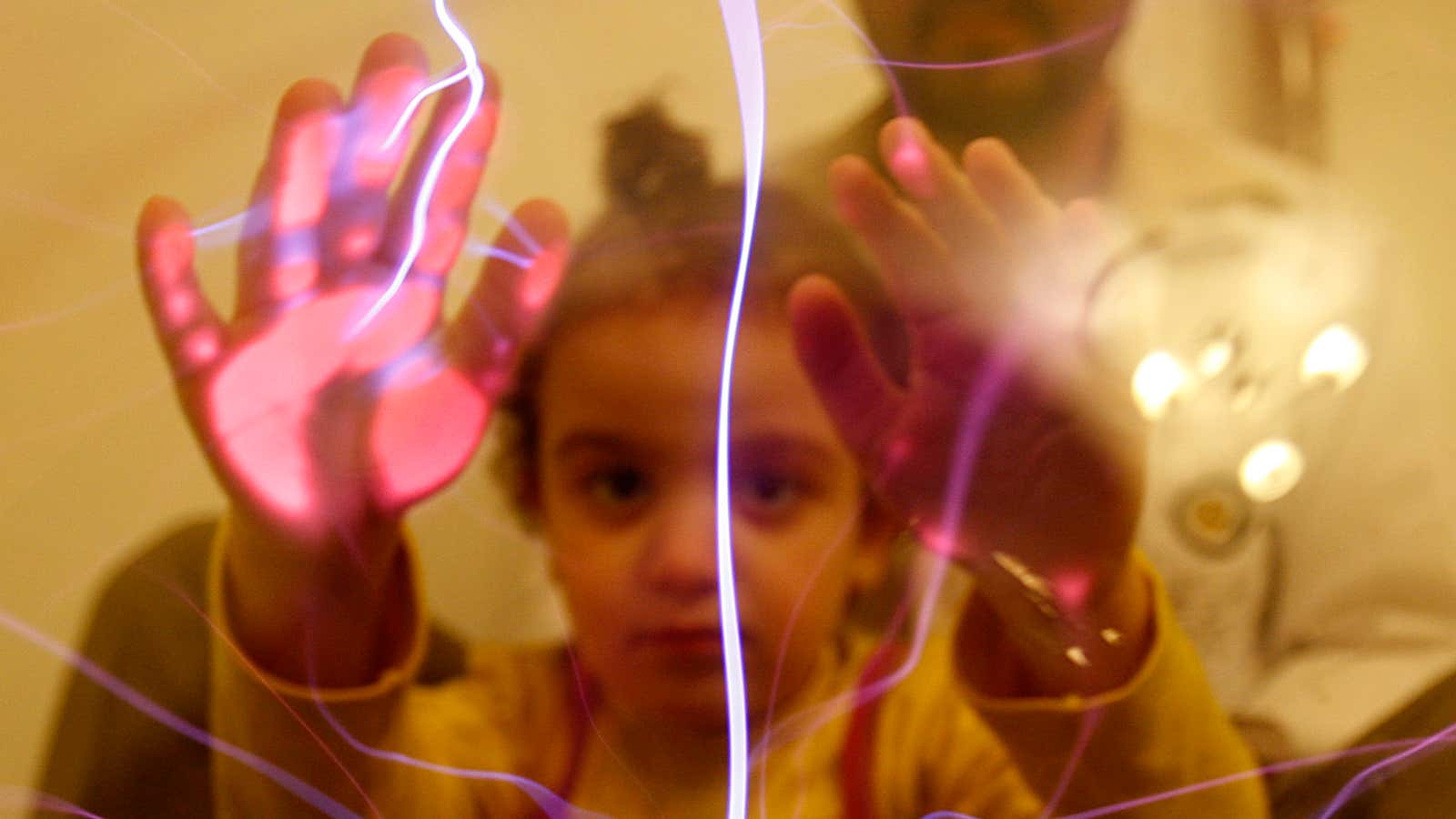 An autistic girl touches an electric globe.