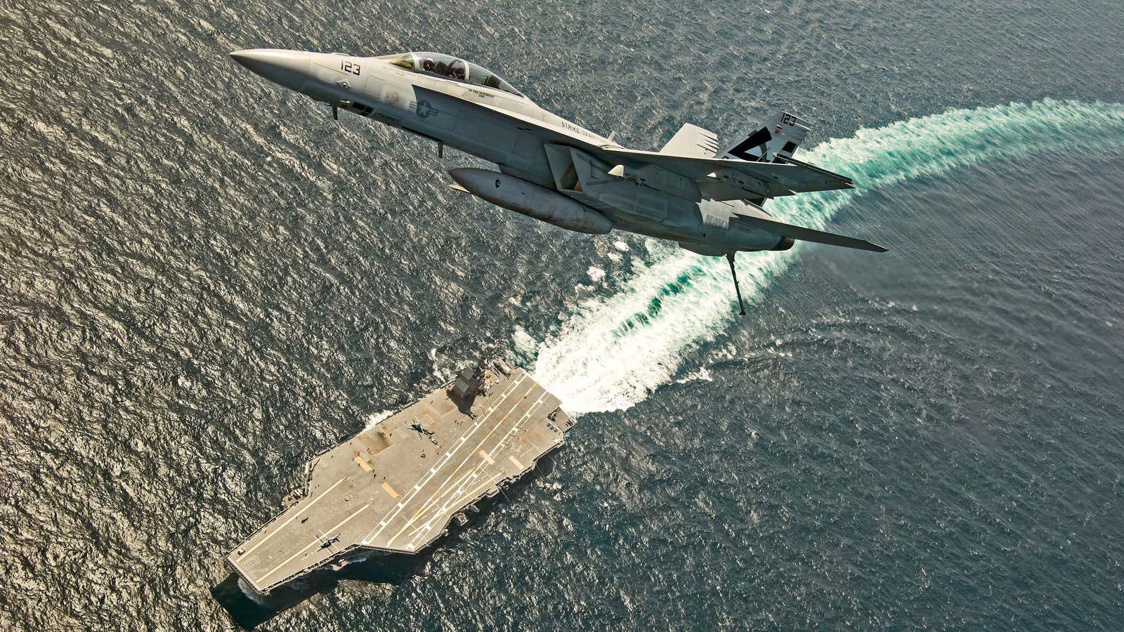 An F/A-18F Super Hornet jet flies over the USS Gerald R. Ford as the U.S. Navy aircraft carrier tests its EMALS magnetic launching system, which replaces the steam catapult, and new AAG arrested landing system in the Atlantic Ocean July 28, 2017. Picture taken July 28, 2017. U.S. Navy/Erik Hildebrandt/Handout via REUTERS ATTENTION EDITORS – THIS IMAGE WAS PROVIDED BY A THIRD PARTY? – RC1C71D03A40