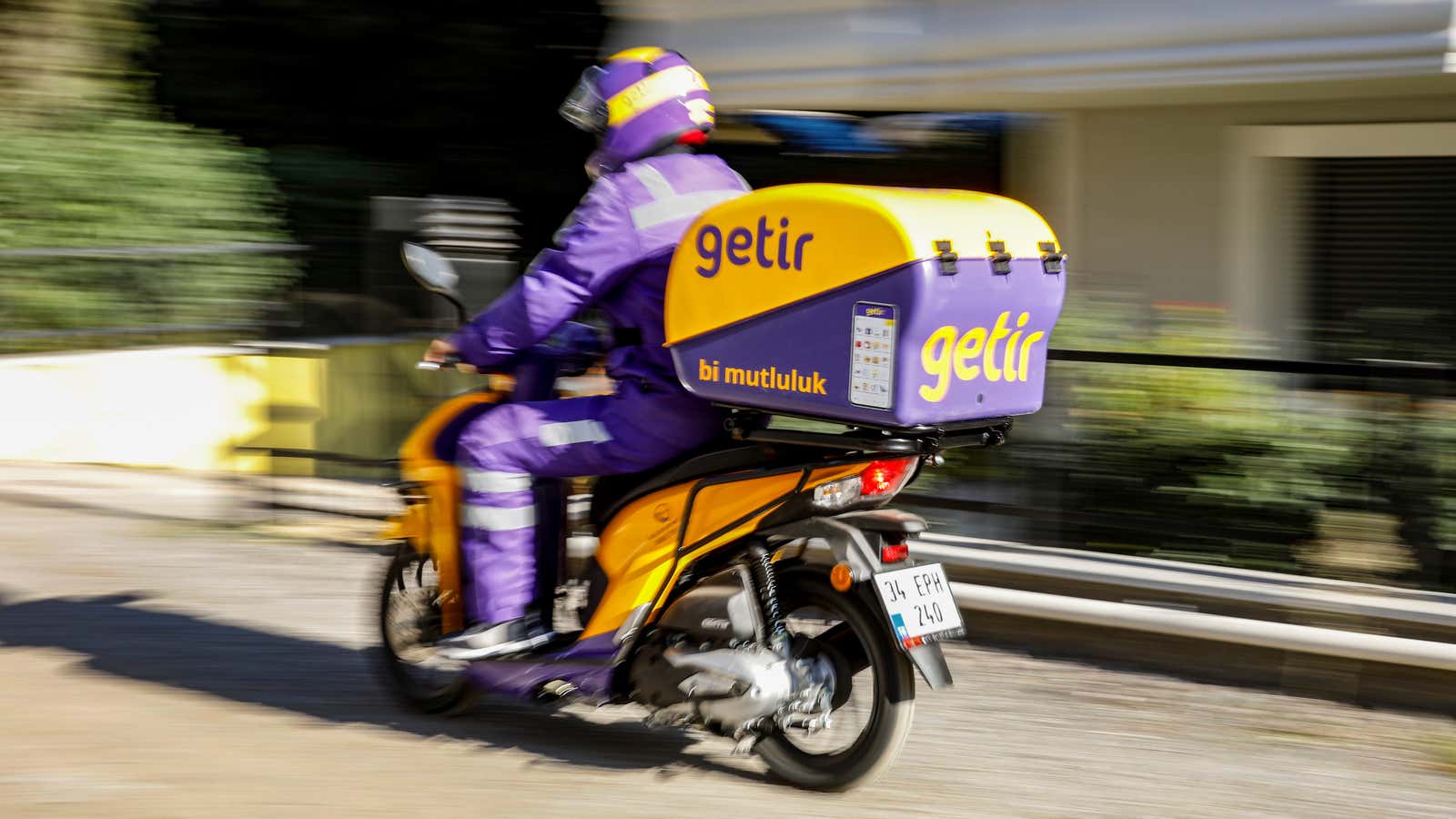 A Getir employee races to make a delivery on a heavily Getir-branded e-bike.