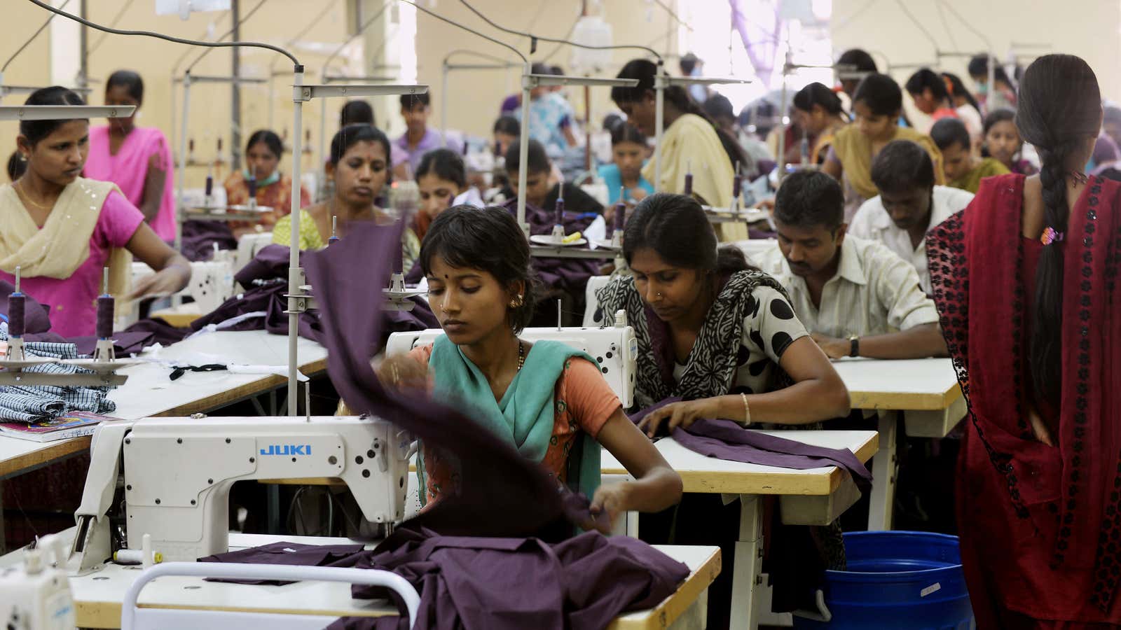 Indian workers of a private garment factory use machines while stitching apparel in Bangalore on November 21, 2012.