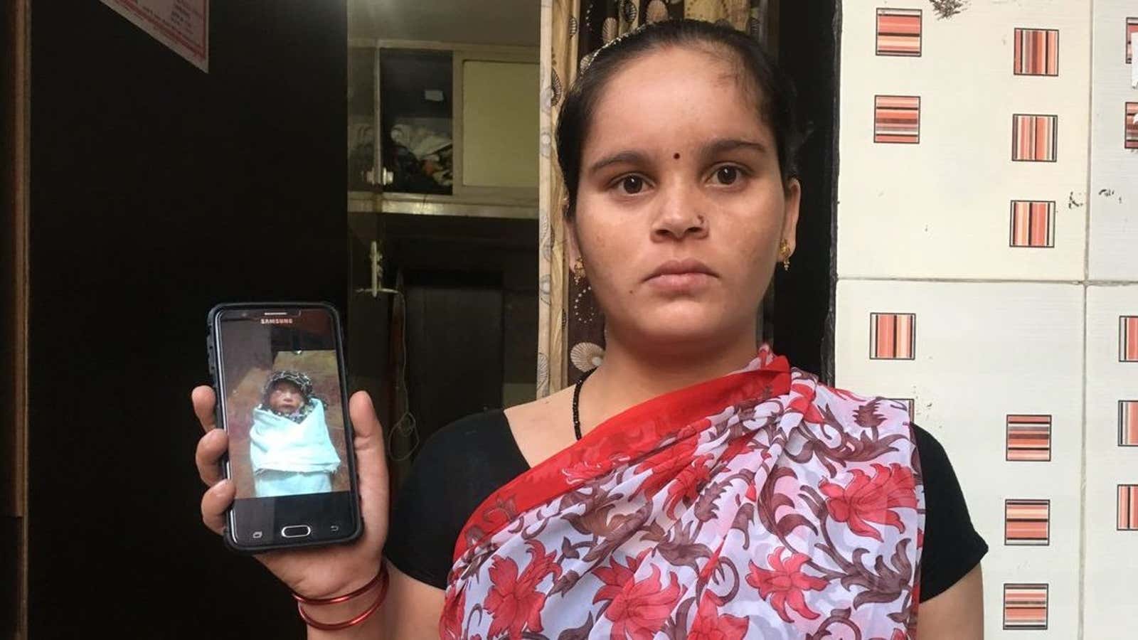 Kiran Sharma holds up a photo of her infant.