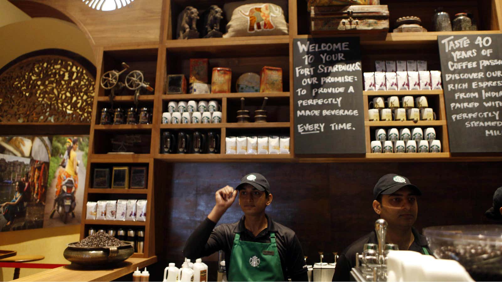 Indian employees of the newly inaugurated first India outlet of Starbucks work at a counter in Mumbai.