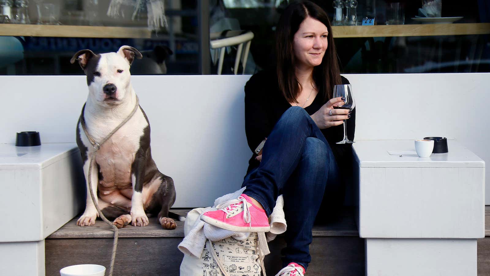 Emilie Liger, from Biarritz, drinks a glass of red wine accompanied by her dog Lara at the terrace of a restaurant in Biarritz, southwestern France,