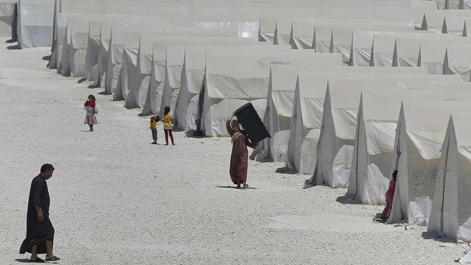 Syrian refugees walk around a refugee camp in Suruc, on the Turkey-Syria border, Friday, June 19, 2015. Ahead of World Refugee Day on Saturday, June…