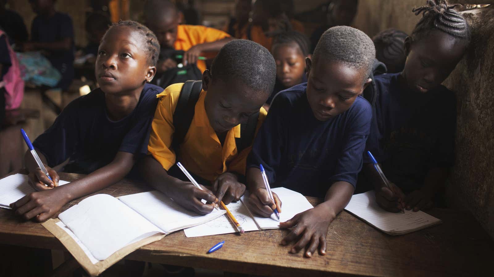 Students share a desk during a mathematics class at the Every Nation Academy private school in the city of Makeni in Sierra Leone, April 20, 2012.     Reuters/Finbarr O’Reilly)