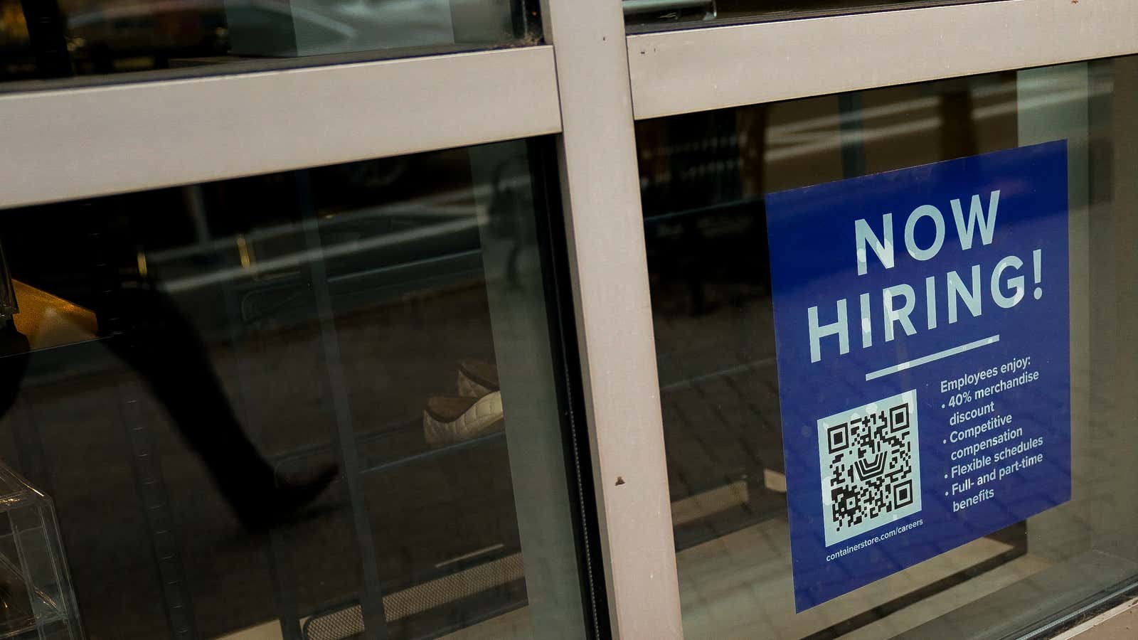 An employee hiring sign in a business window
