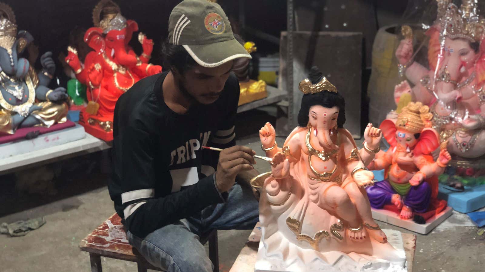 An artist paints a Ganesh idol.