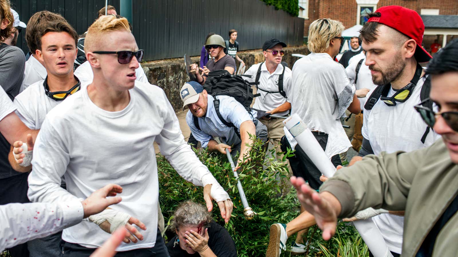 Michael Miselis, wearing the red hat, stands over a bloodied demonstrator in Charlottesville.