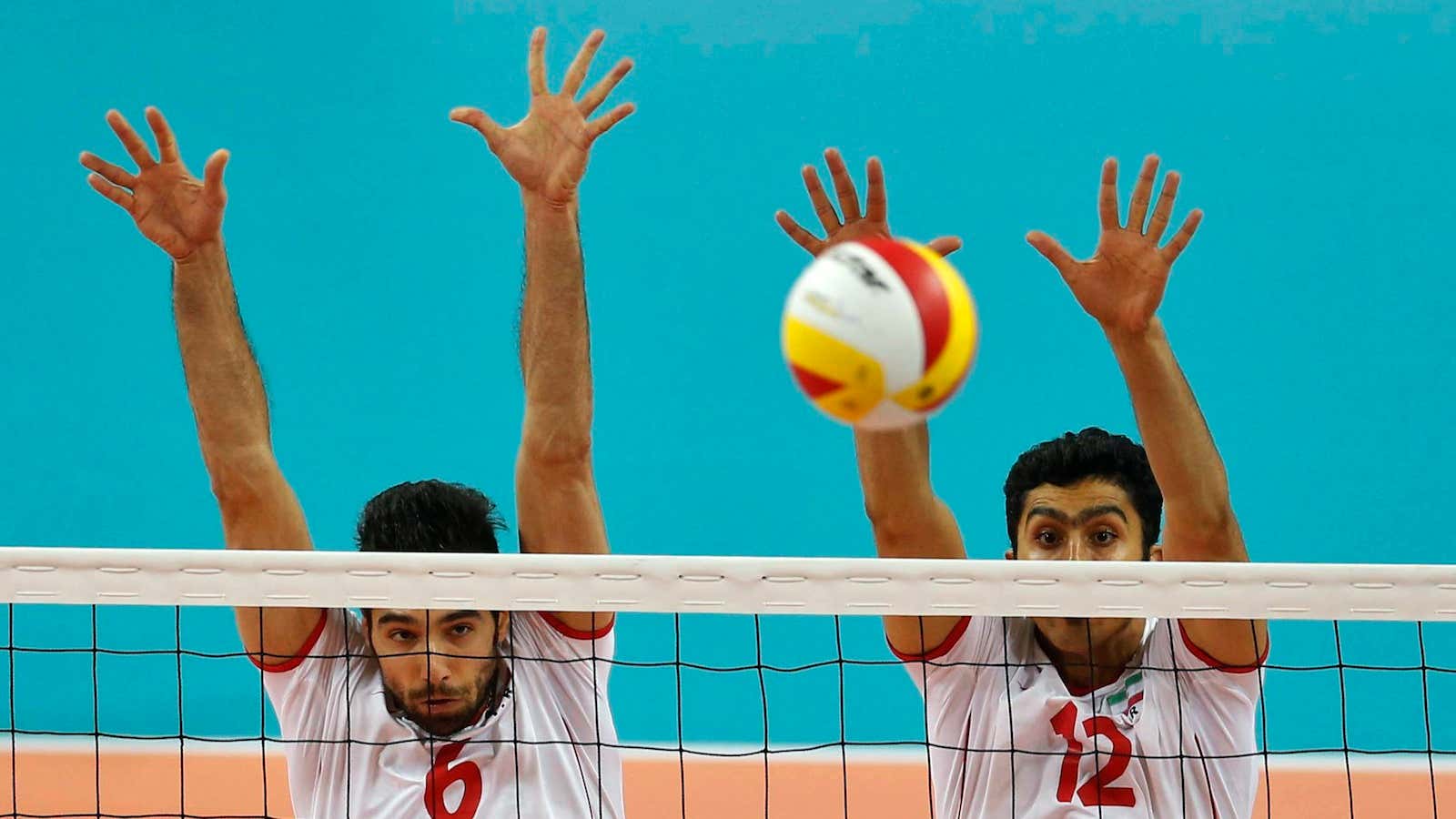 Iran’s Seyed Mohammad Mousavi Eraghi (left) and Mojtaba Mirzajanpourmouziraji defend the net during a 2014 Asian Games volleyball match against Japan.