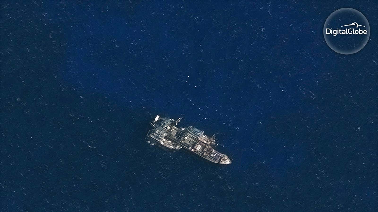A refrigerated cargo vessel meeting with two fishing vessels in the Indian Ocean.
