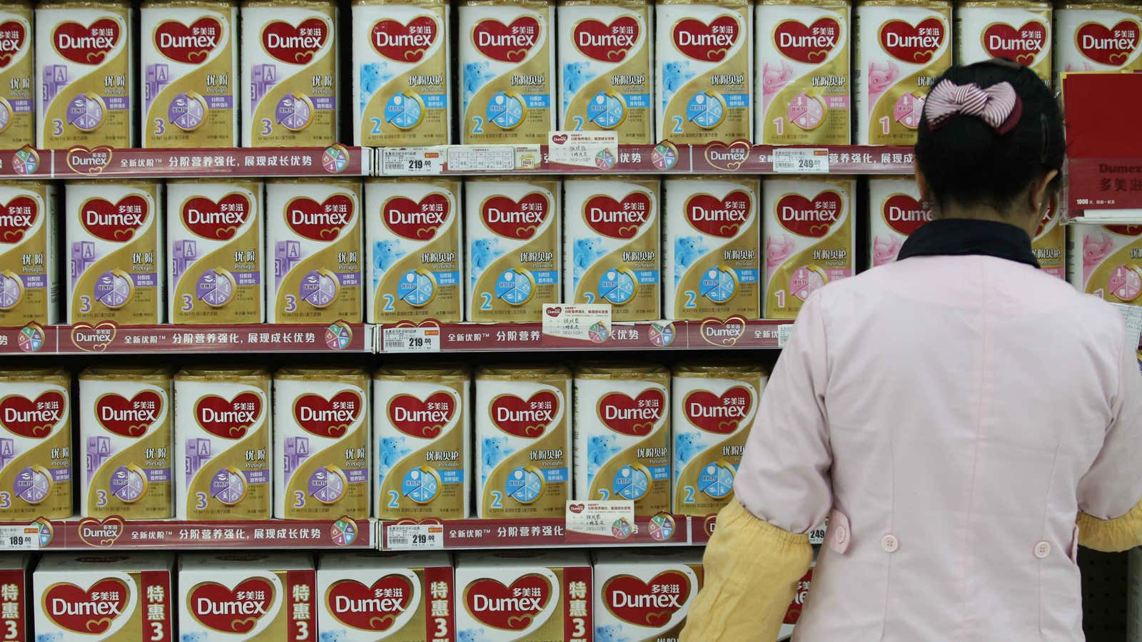 A Chinese employee checks imported canned milk powder at a supermarket in Nantong city, Jiangsu Province.