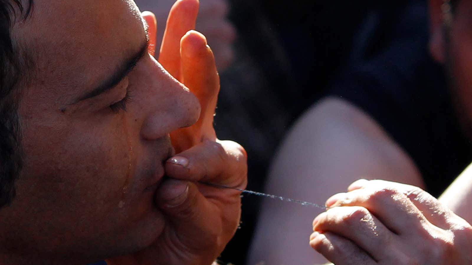 A migrant protests as he waits with others to cross the border from Greece.