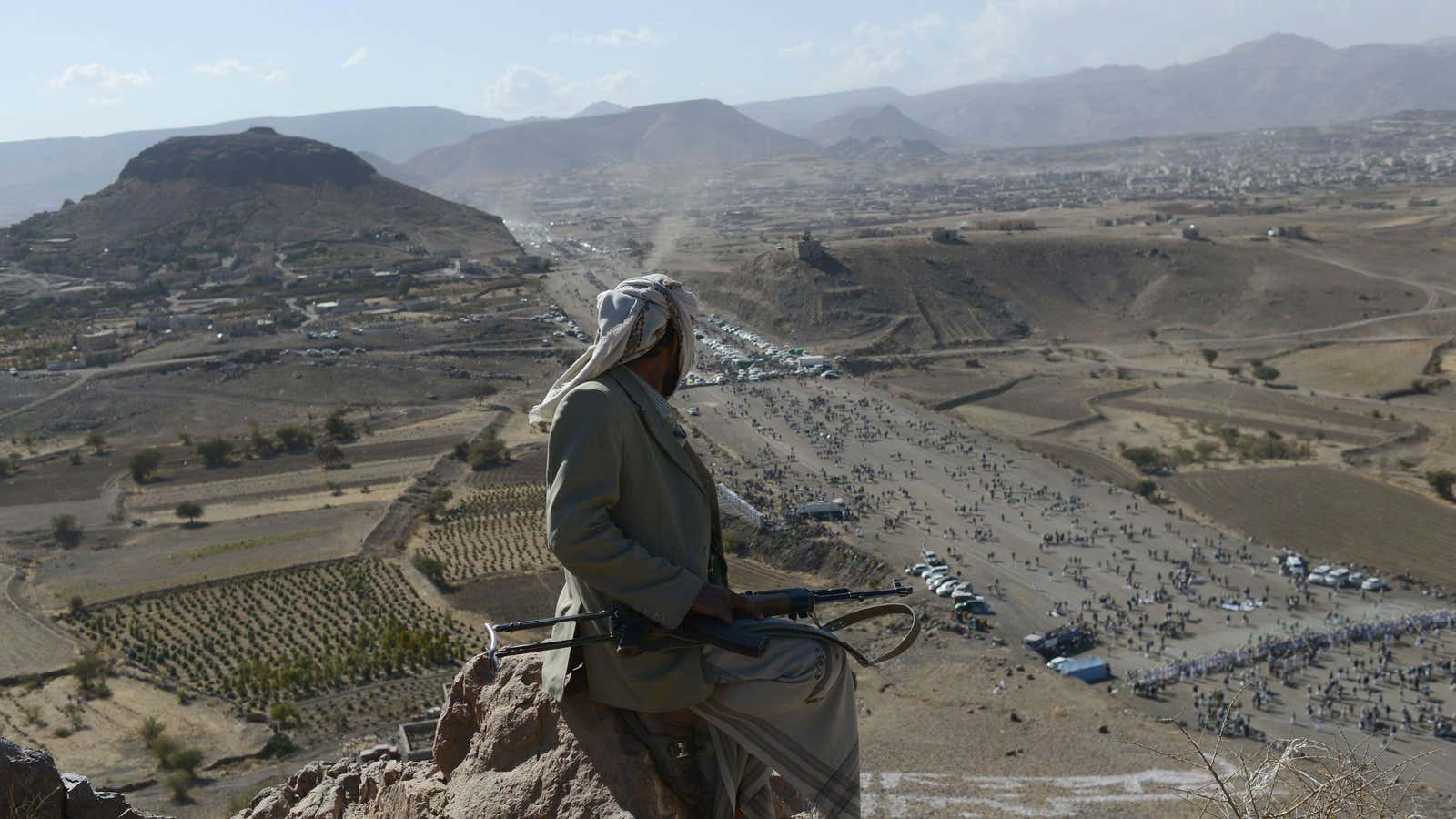 A Yemeni tribesman keeps watch from the top of a mountain during a Houthi gathering for Mawlid al Naby—birthday of the Prophet Mohammad, January 24, 2013 in Heziez, Yemen.