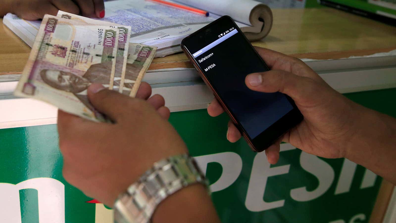 A customer conducts a mobile money transfer, with M-Pesa, at a Safaricom agent stall