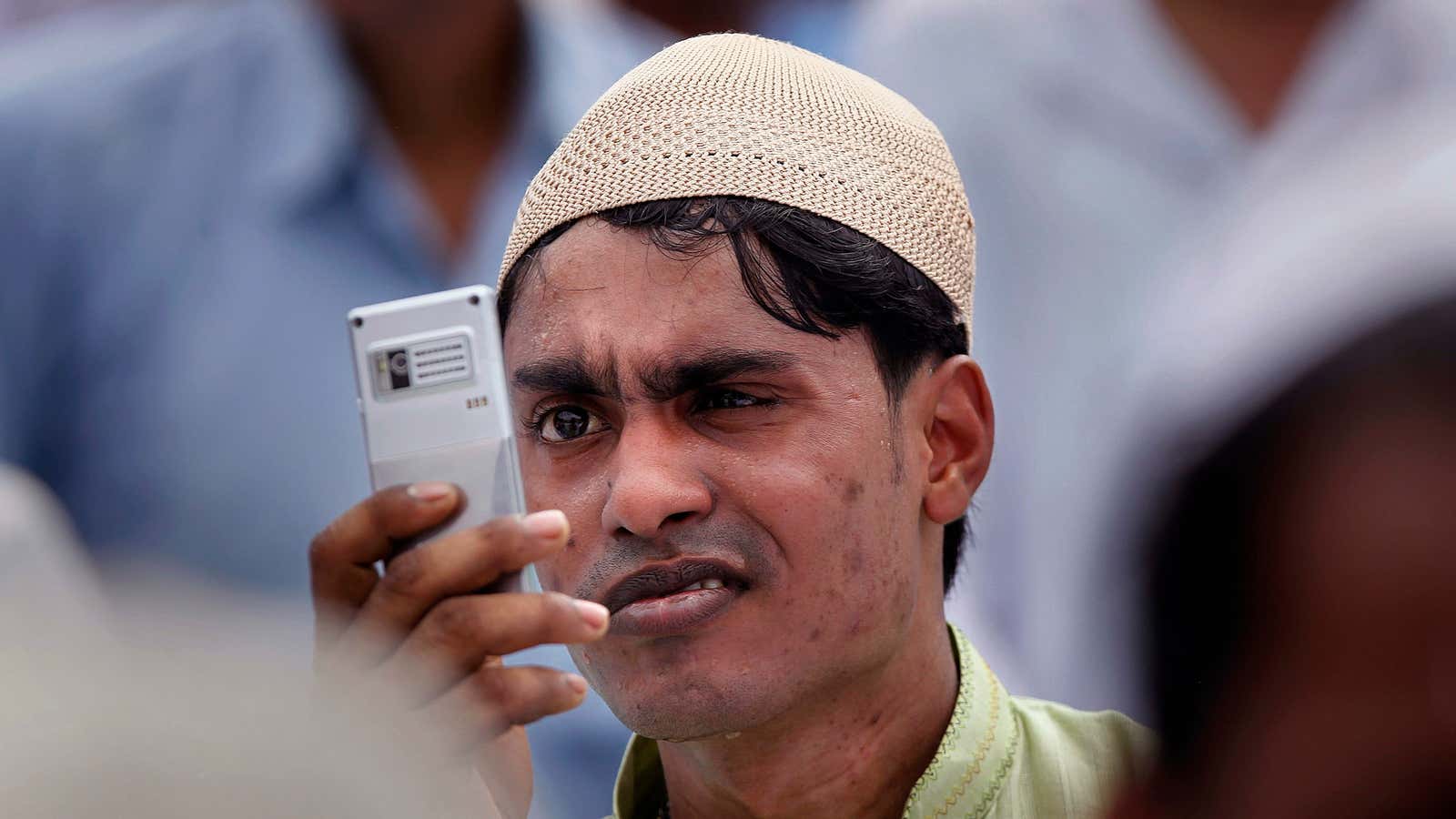 Is he taking pictures or watching the cricket?