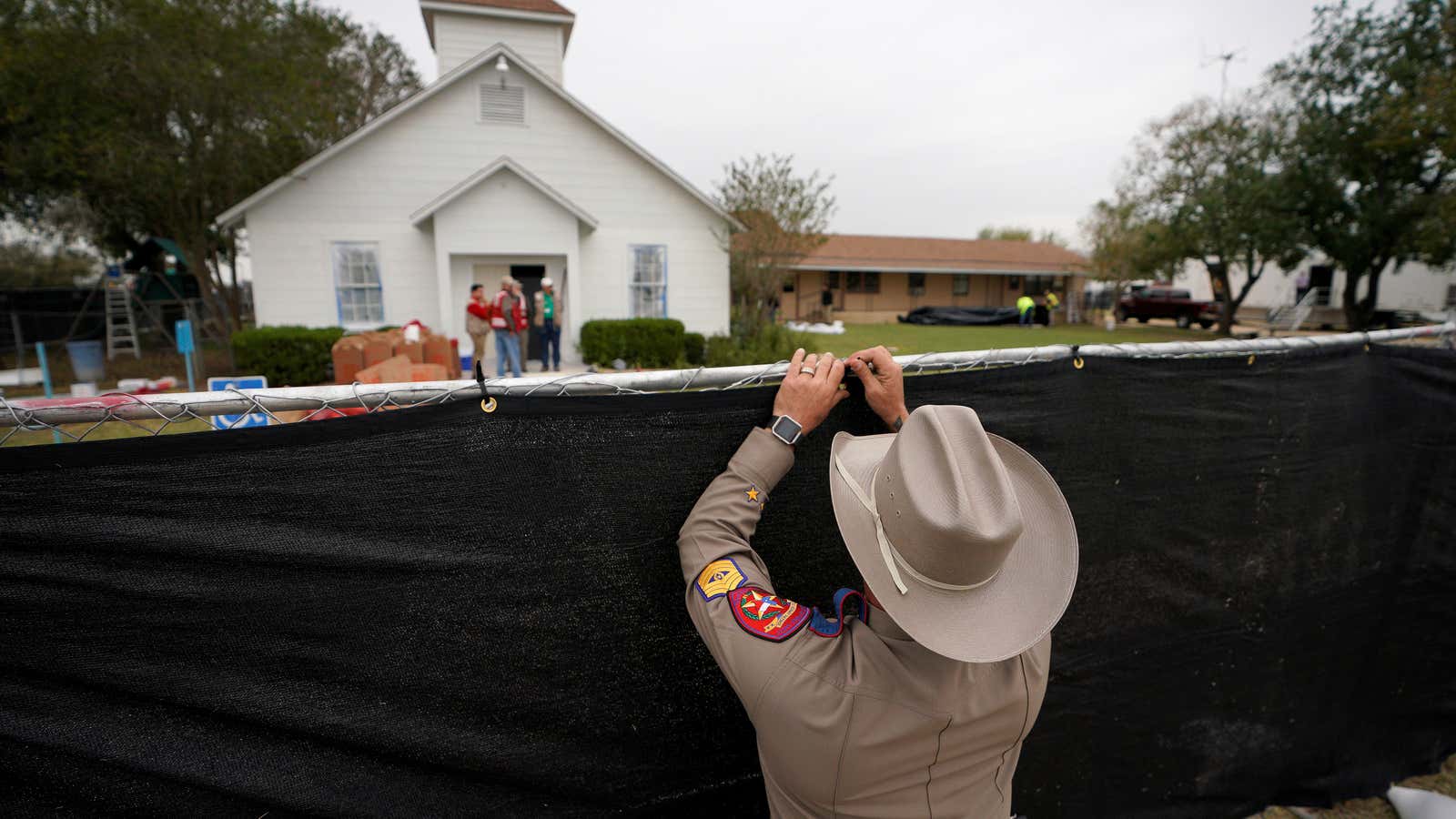 A Texas state trooper helps erect a fence around the site of the shooting at the First Baptist Church of Sutherland Springs, Texas, on Nov. 9, 2017