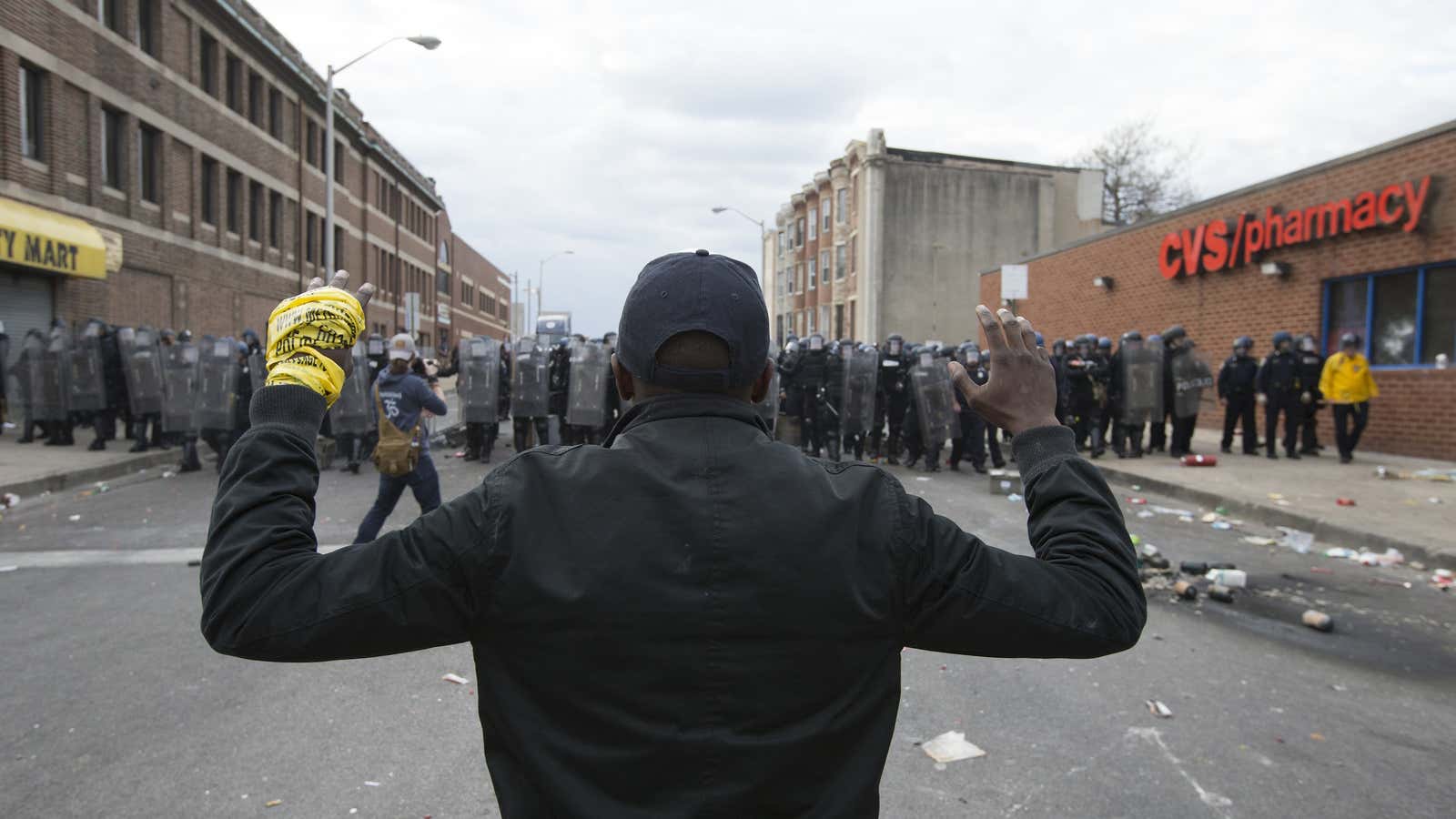 A youth stands in front of a police line as protests of the death of Freddie Gray continue, in Baltimore, Maryland, on April 27, 2015.