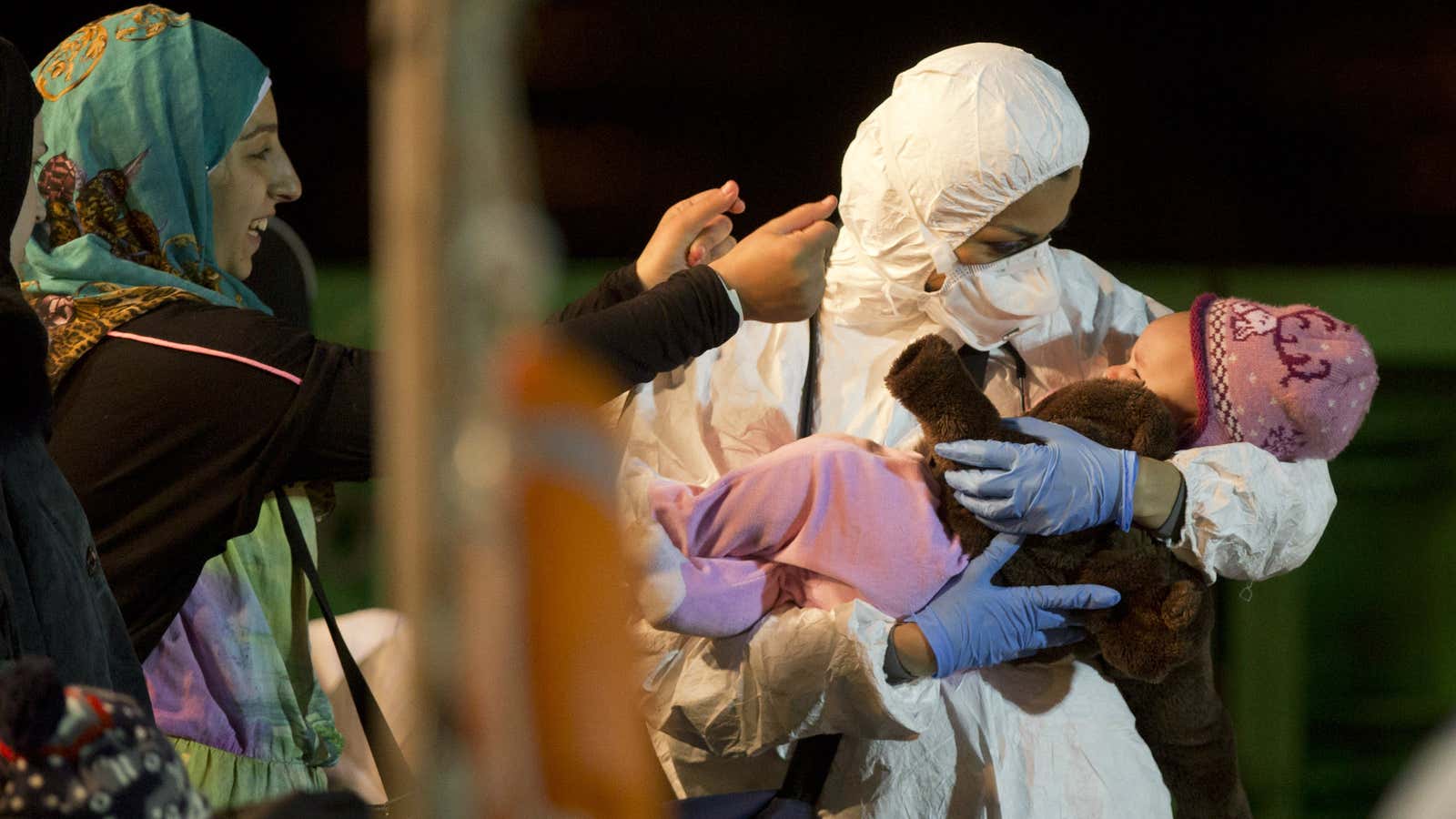 A rescuer cradles a child in Pozzallo, Italy, part of a group of about 100 migrants that were rescued by a merchant vessel, shortly after a larger ship overturned off Libya’s coast .