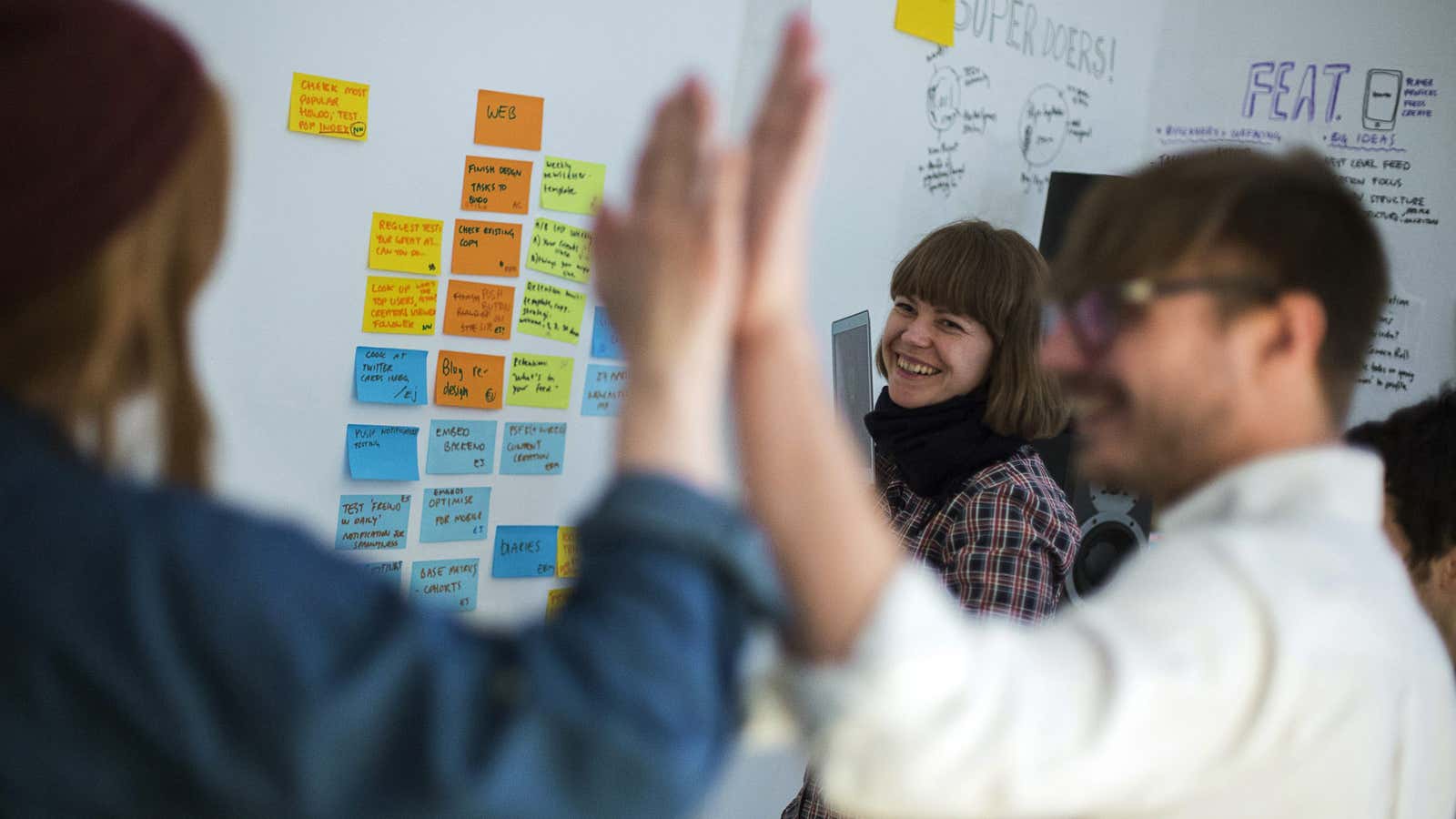 Emma Rose of Britain and Sweden’s Nils Westerlund and Sofia Braendstroem (L-R) of the HowDo start-up attend a production meeting at their office at the…